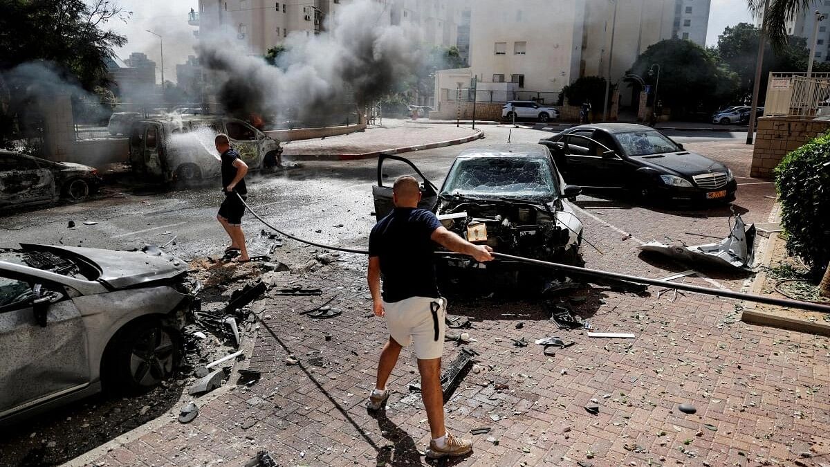 <div class="paragraphs"><p>People work to put out a fire engulfing a van, as rockets are launched from the Gaza Strip, in Ashkelon, southern Israel.</p></div>