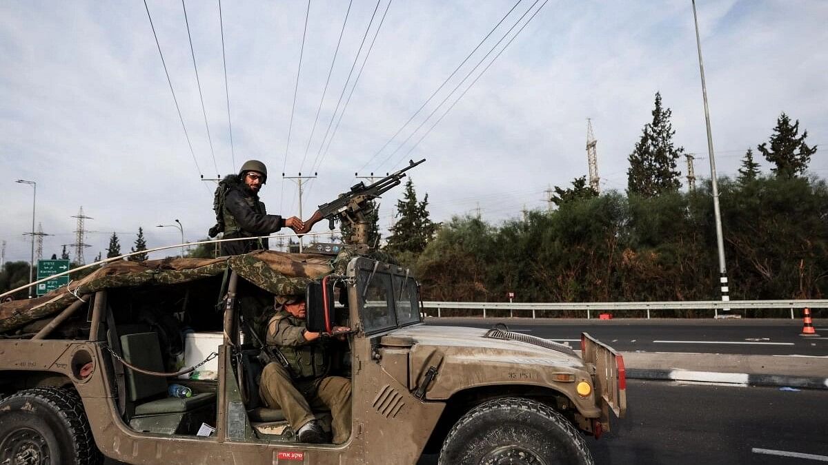 <div class="paragraphs"><p>Israeli soldiers ride in a military vehicle near Israel's border with Gaza, in southern Israel.&nbsp;</p></div>