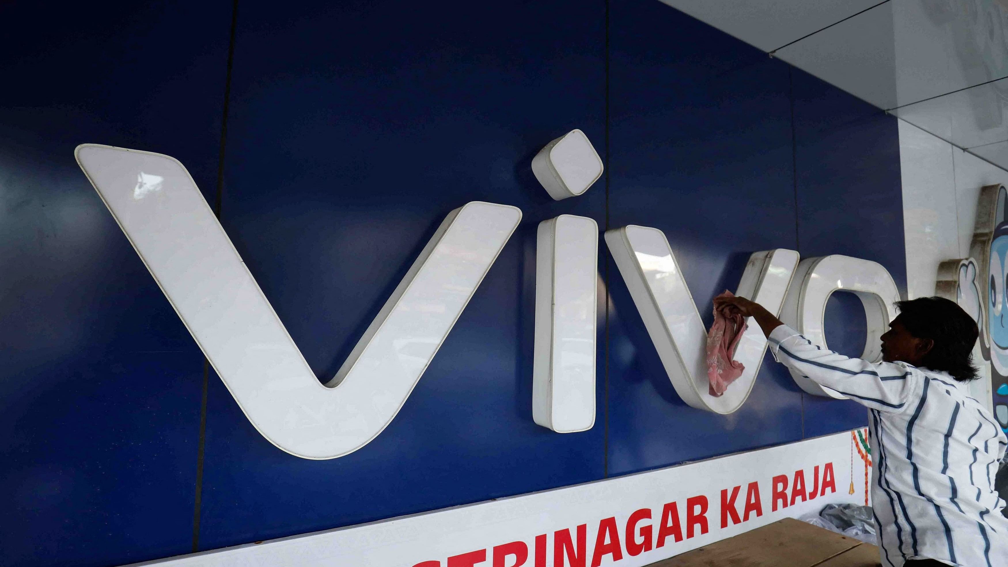 <div class="paragraphs"><p>A man cleans the logo of a Chinese smartphone brand Vivo outside a store in Ahmedabad.&nbsp;</p></div><div class="paragraphs"><p><strong><br></strong></p></div>
