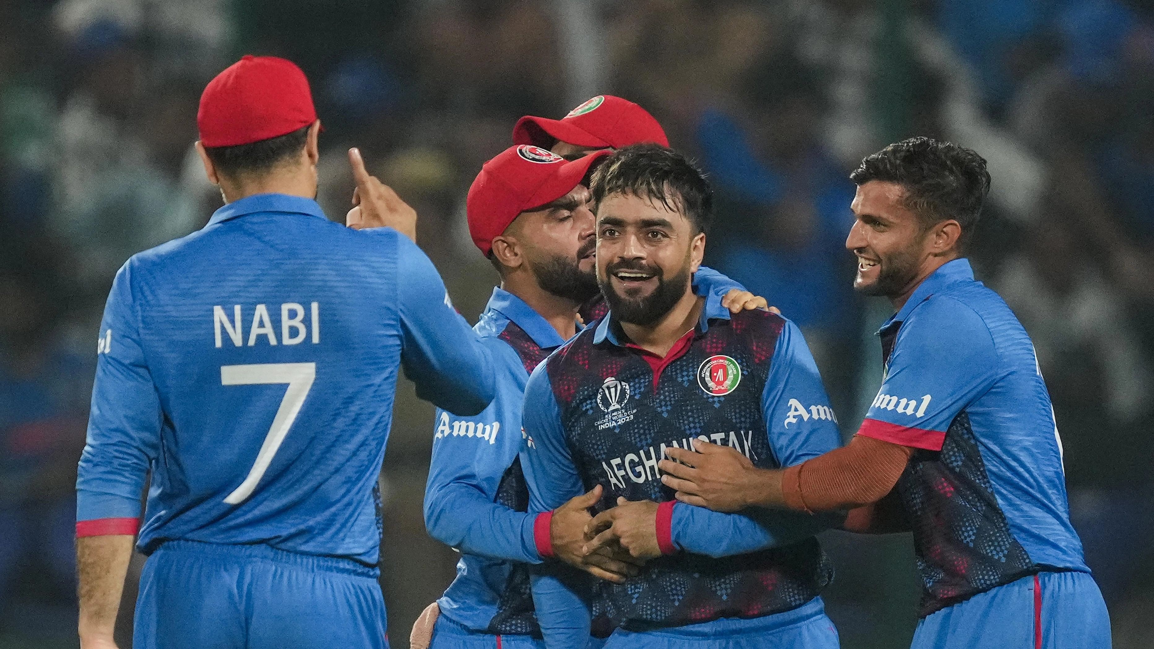 <div class="paragraphs"><p>Afghanistan's Rashid Khan with teamamtes celebrates the wicket of England's Liam Livingstone during the ICC Men's Cricket World Cup 2023 match between Afghanistan and England, at Arun Jaitley Stadium in New Delhi, Sunday.</p></div>