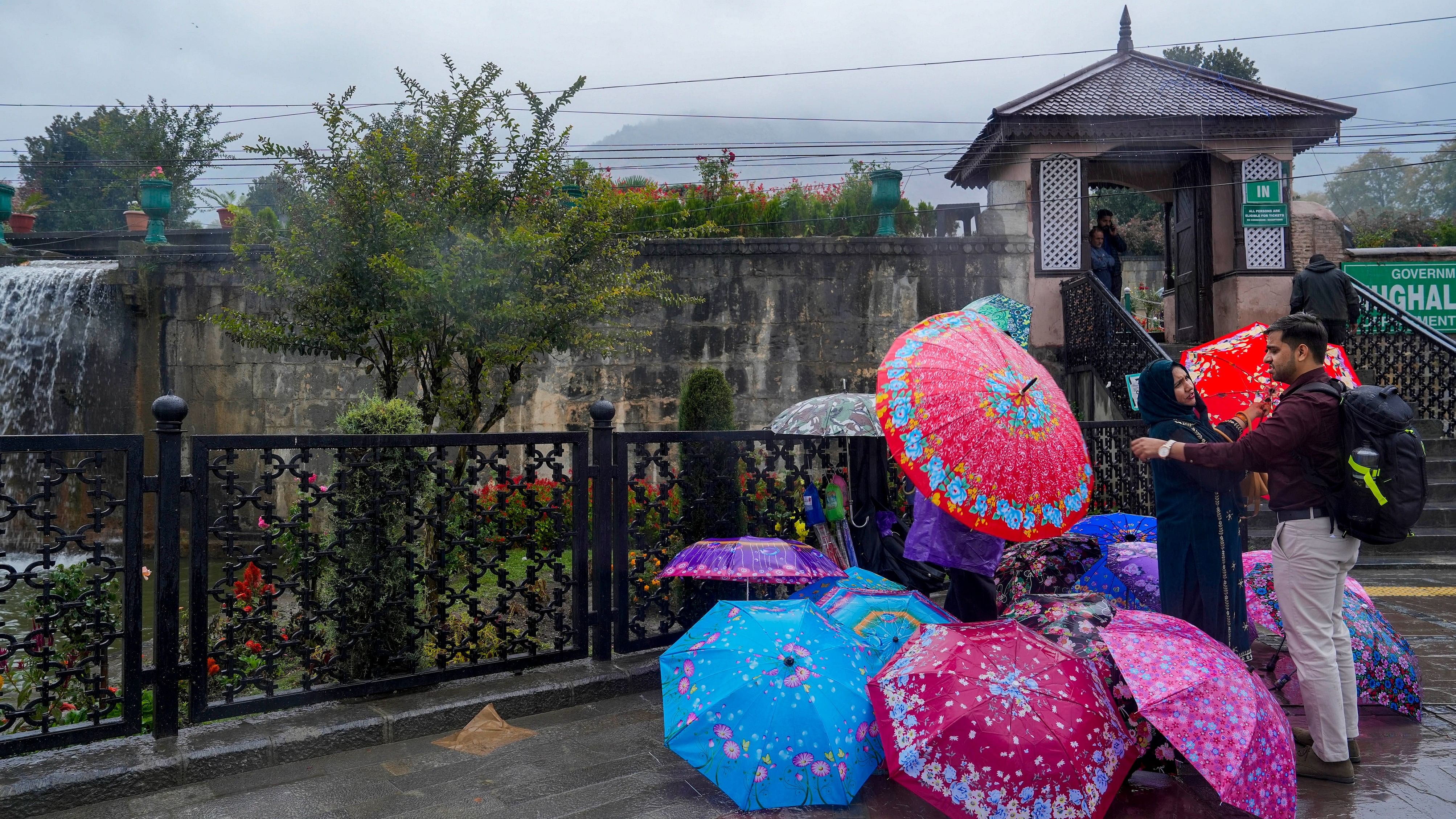 <div class="paragraphs"><p>Tourists buy umbrellas  outside the Mughal Garden, in Srinagar, Monday, Oct. 16, 2023. Higher reaches of the Valley witnessed light to moderate snowfall while the plains were lashed by rain.</p></div>