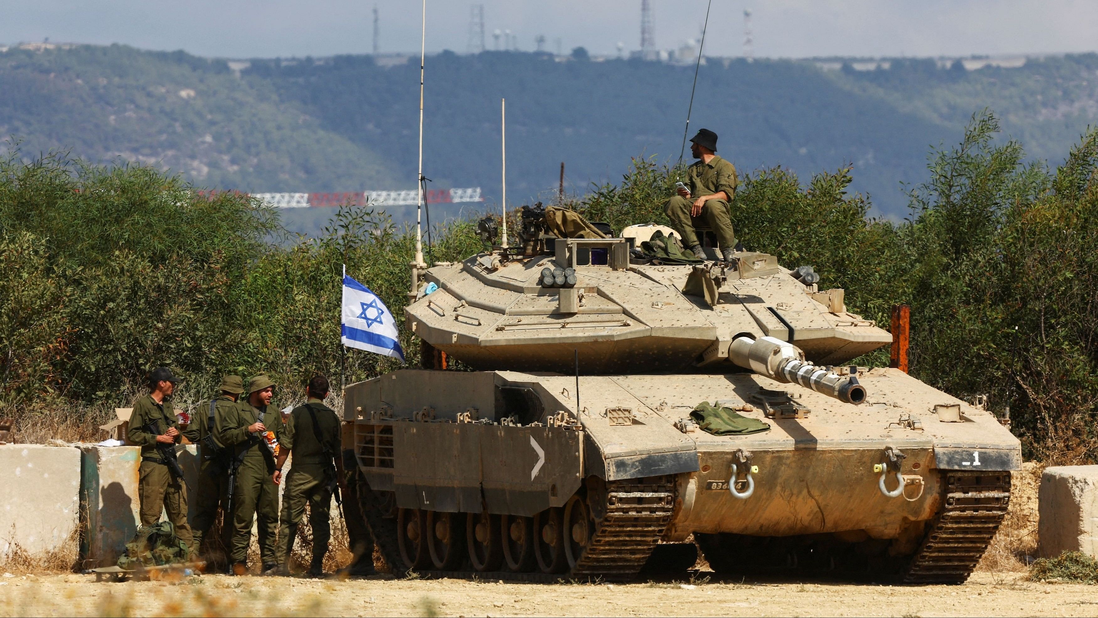 <div class="paragraphs"><p>Israeli soldiers stand next to a tank near Israel's border with Lebanon in northern Israel, October 16, 2023. </p></div>