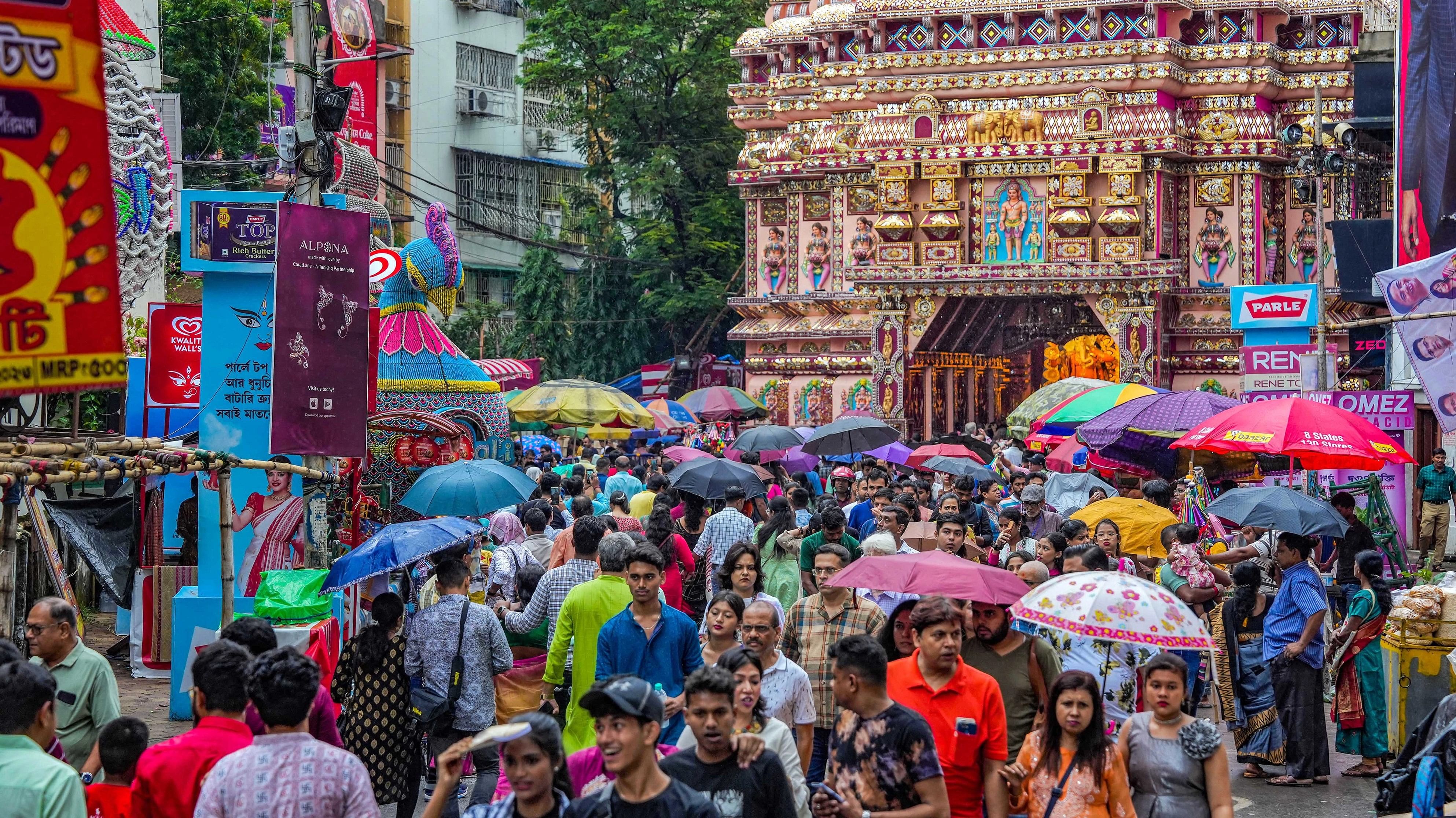 <div class="paragraphs"><p>Devotees use umbrellas to protect themseves from rains as they visit a community puja pandal on the  'Navami' of the Durga Puja festival, in Kolkata, Monday, Oct. 23, 2023.</p></div>