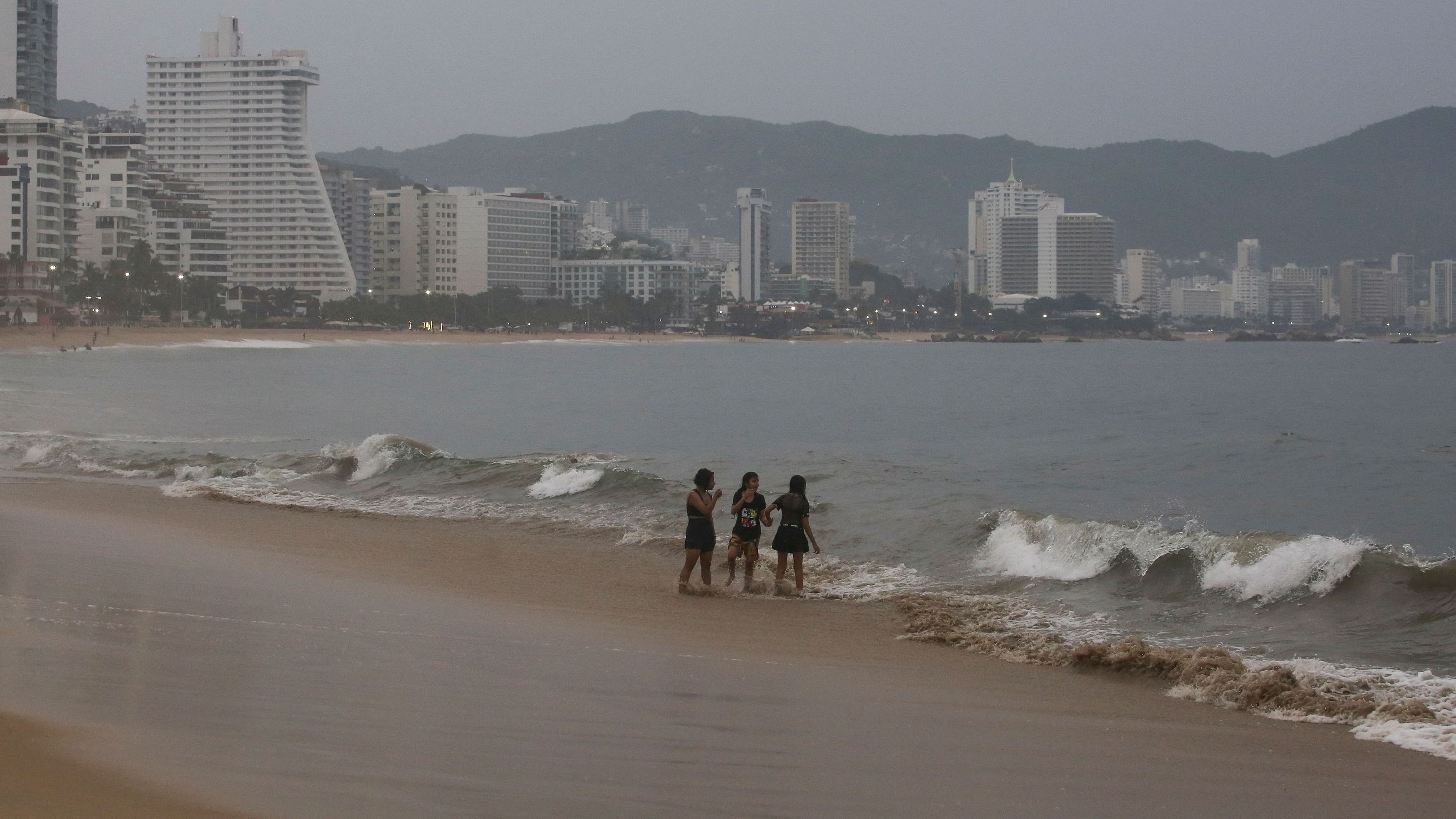 <div class="paragraphs"><p>People stand on a beach as Hurricane Otis barrels towards Acapulco, Mexico, October 24, 2023.</p></div>