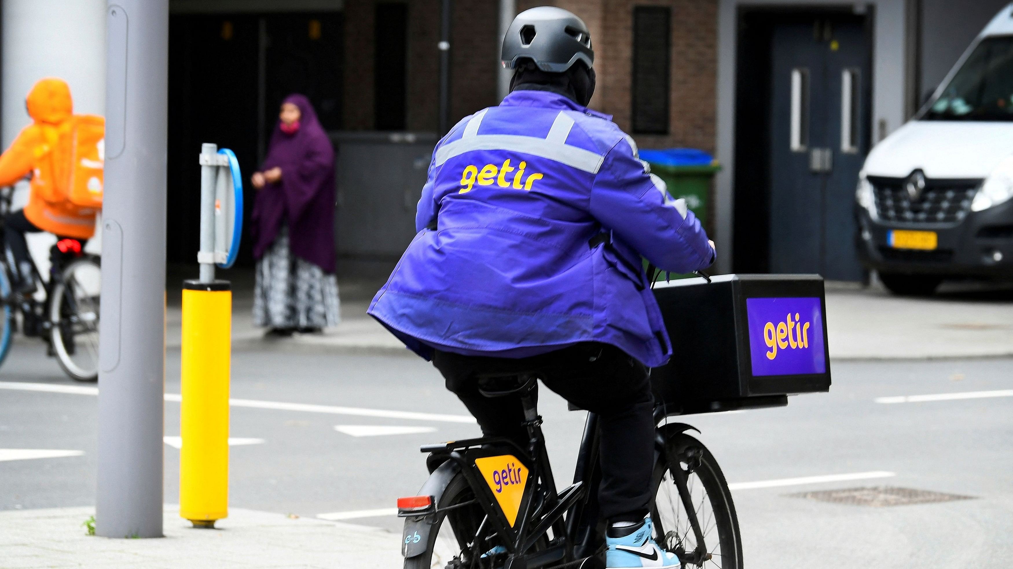 <div class="paragraphs"><p>A courier of the fast grocery deliverer Getir rides a bike in Amsterdam.</p></div>
