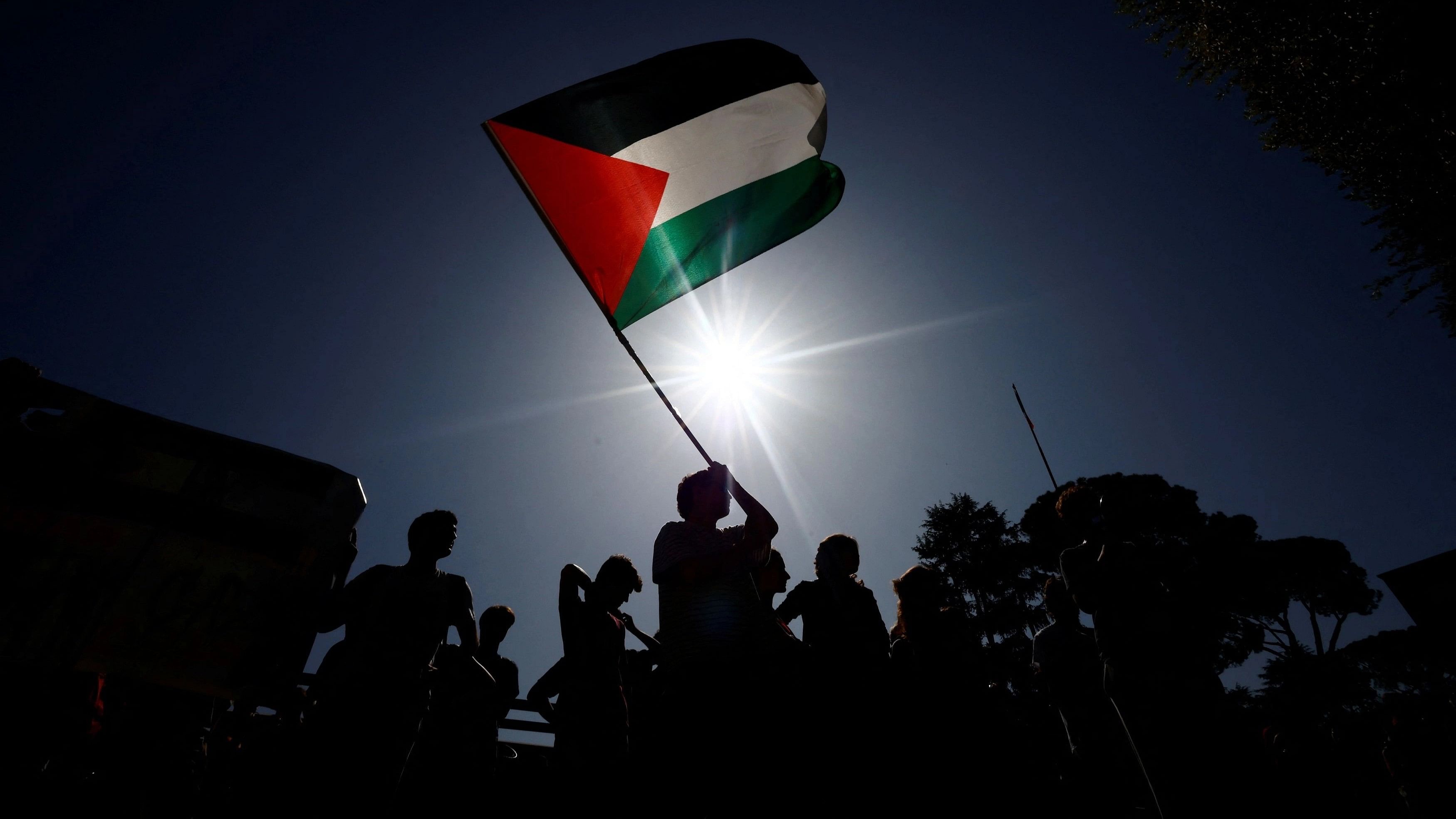 <div class="paragraphs"><p>A person holds a Palestinian flag as students demonstrate to express support for the people of Palestine in Rome.</p></div>