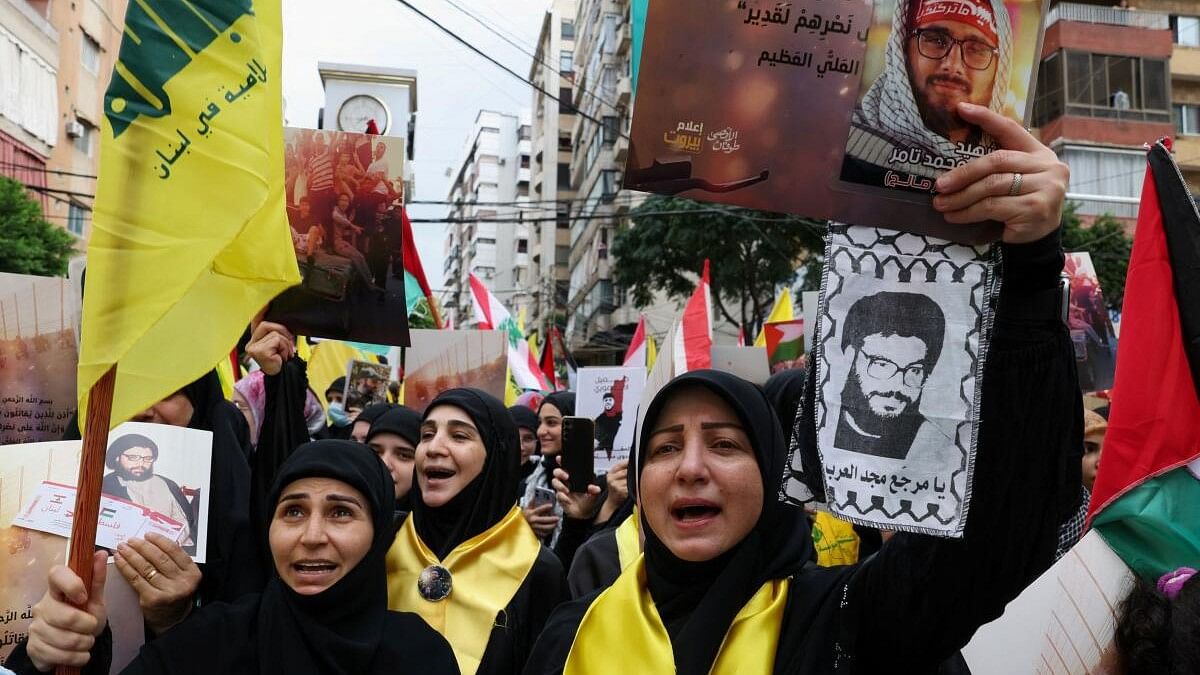 <div class="paragraphs"><p>Seham Haydoura, Hawraa Al Rez and Abir Khalil carry banners and flags during a rally to express solidarity with the Palestinians, in Beirut's southern suburbs, Lebanon October 8, 2023.</p></div>