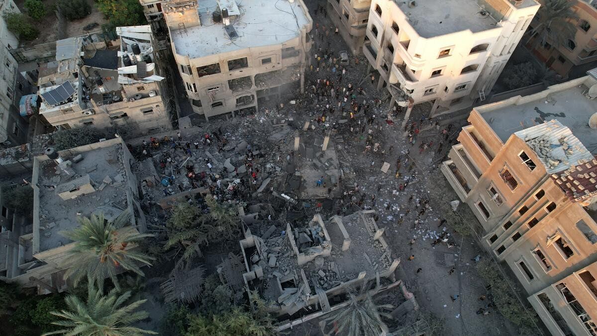 <div class="paragraphs"><p>People gather at the site of Israeli strikes on houses in the central Gaza Strip, October 18, 2023.</p></div>