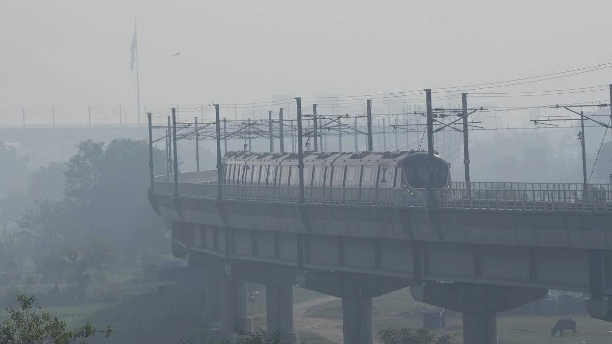 <div class="paragraphs"><p>A metro train runs on its track amid smog, in New Delhi.</p></div>