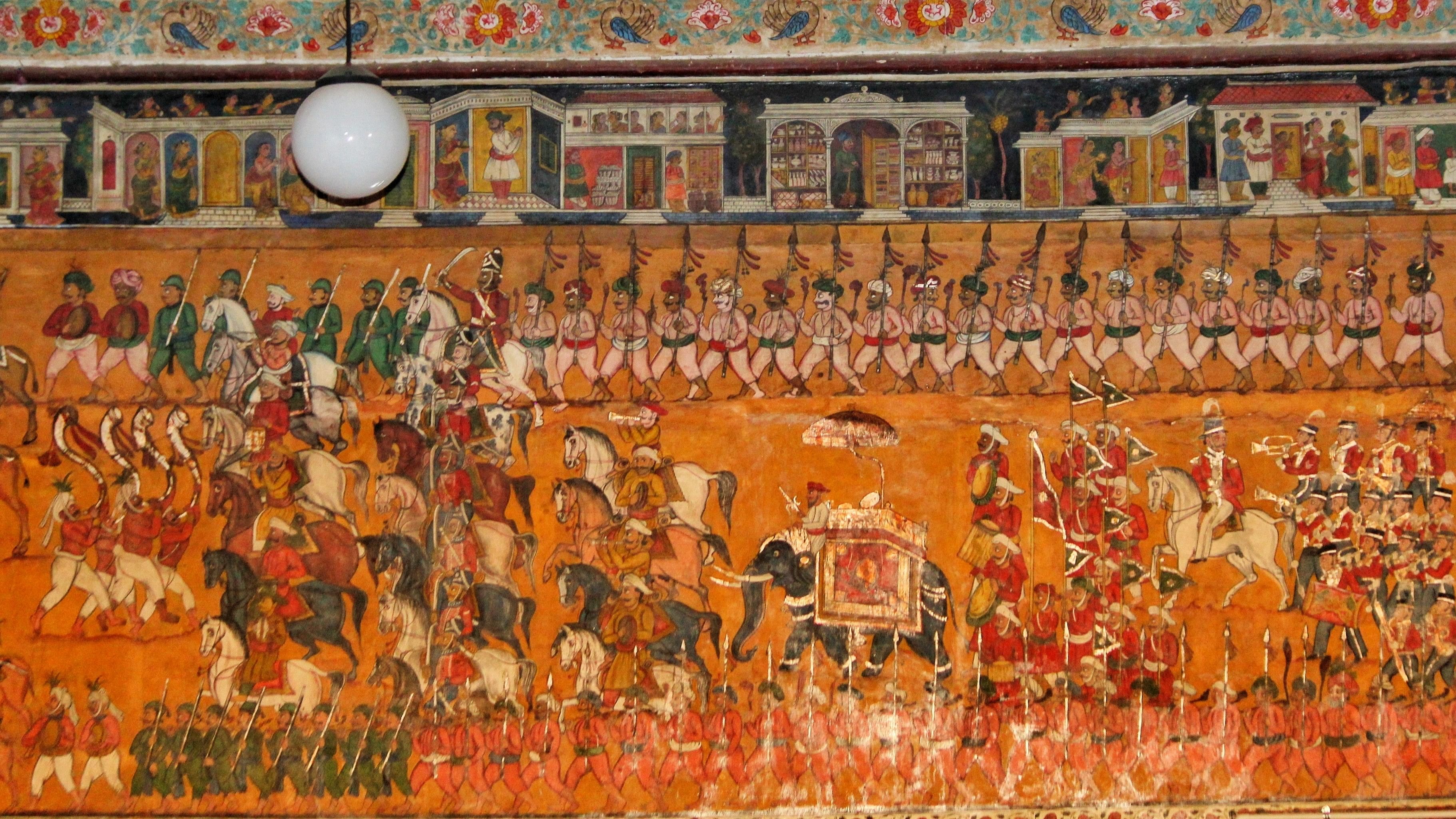 <div class="paragraphs"><p>Murals of the Mysore Dasara procession, presided over by Mummadi Krishnaraja Wadiyar, on the wall at Jaganmohan Palace. </p></div>