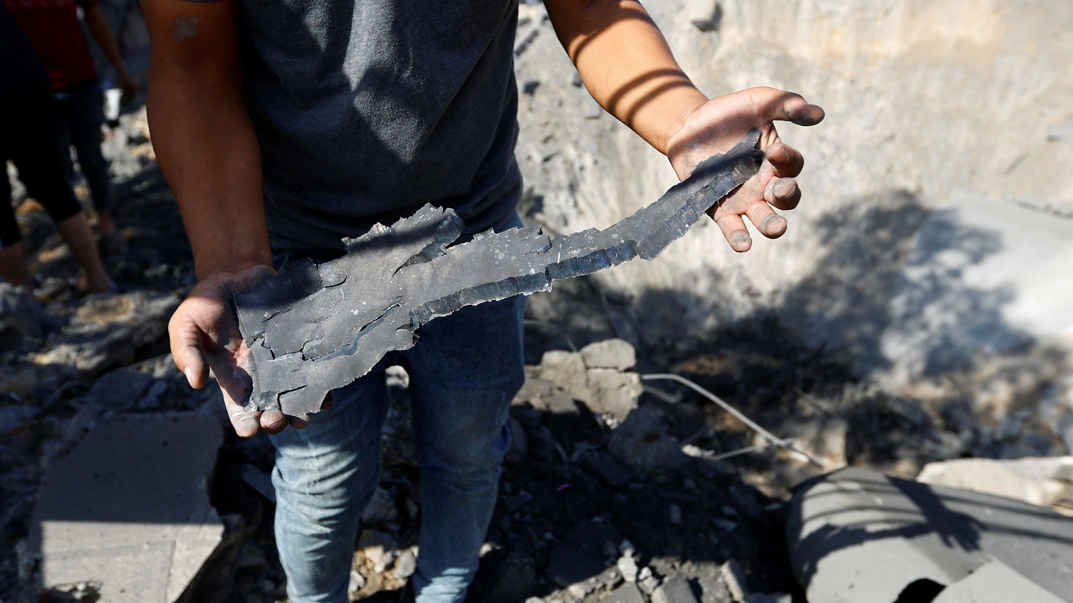 <div class="paragraphs"><p>A person shows a piece of a missile at the site where a girl was killed in Israeli strikes on a house in Khan Younis, amid the ongoing conflict between Israel and Palestinian Islamist group Hamas, in the southern Gaza Strip, October 19, 2023.</p></div>