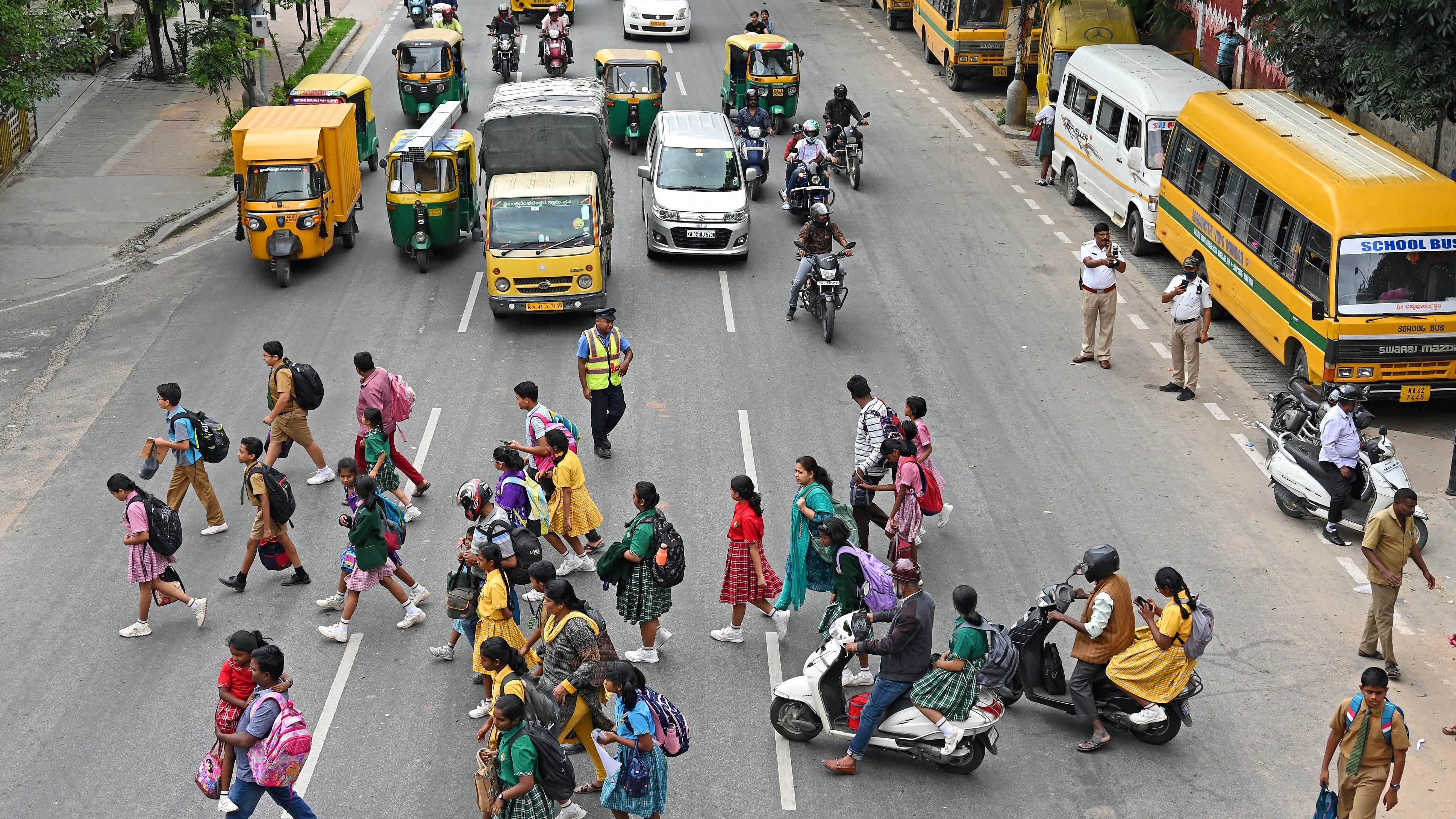 <div class="paragraphs"><p>School children cross the busy Residency Road which witnesses slow moving traffic when schools and colleges in the area close for the day. </p></div>