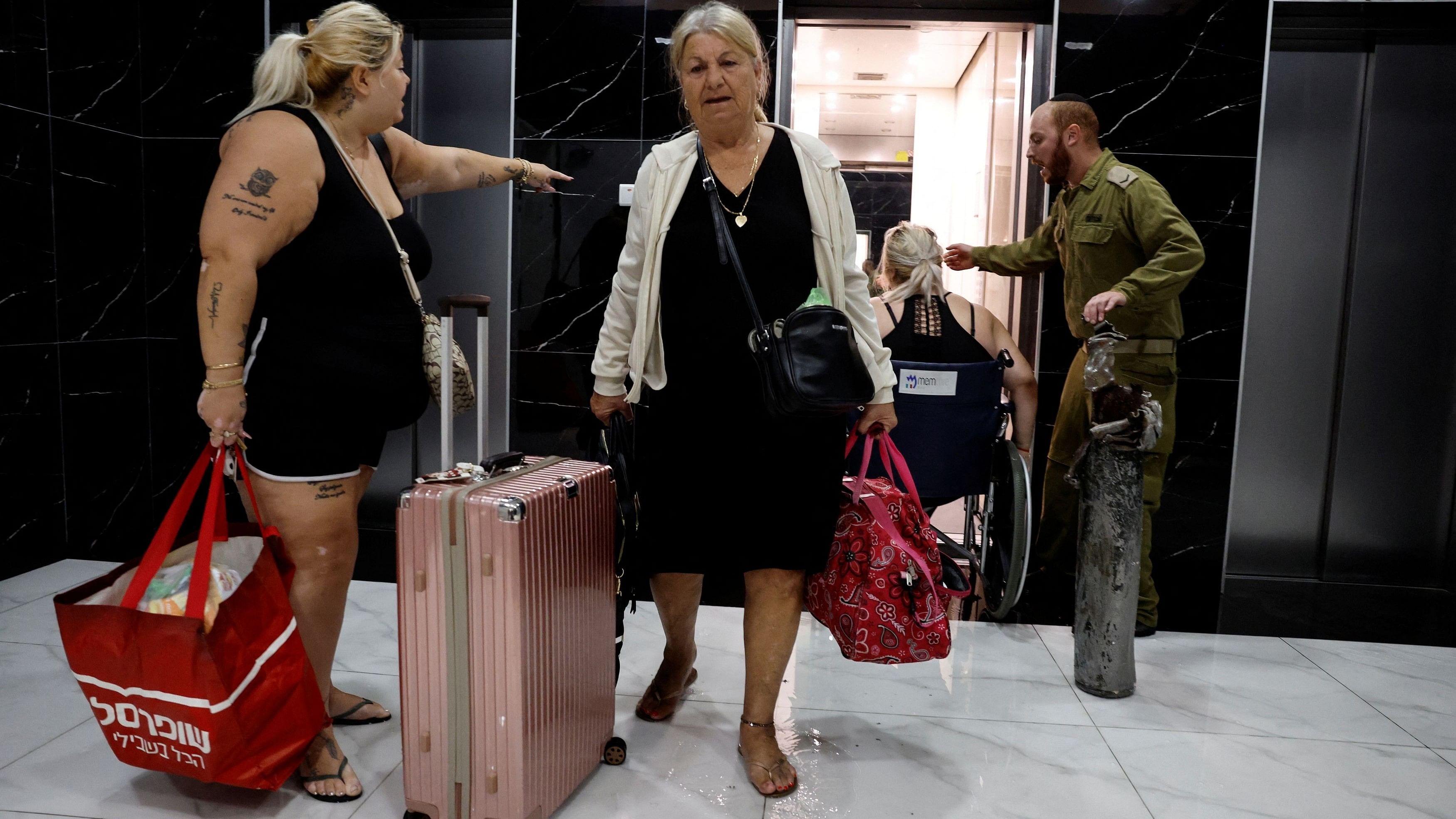 <div class="paragraphs"><p>An Israeli military reservist helps residents of Ashkelon evacuate the city as he holds a rocket that was launched from the Gaza Strip and landed in Ashkelon, southern Israel.</p></div>