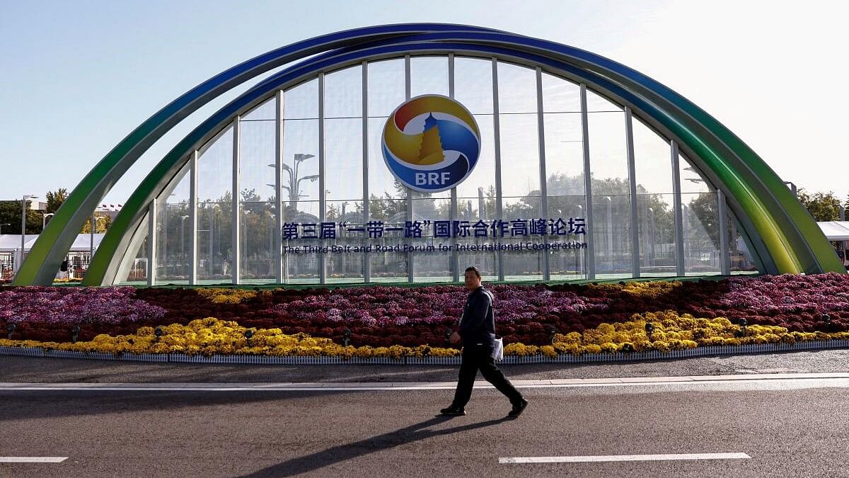 <div class="paragraphs"><p>A person walks past a sign of the Third Belt and Road Forum ahead of its opening ceremony, at the media centre in Beijing.</p></div>