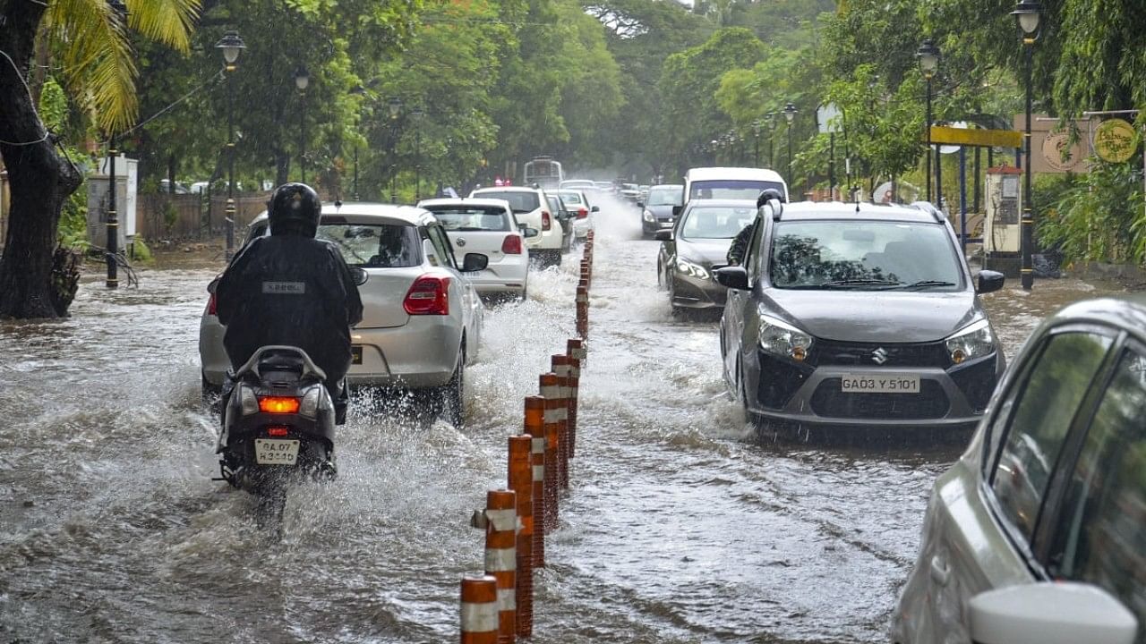 <div class="paragraphs"><p>Vehicles wade through a waterlogged road after heavy rain in Panaji. </p></div>