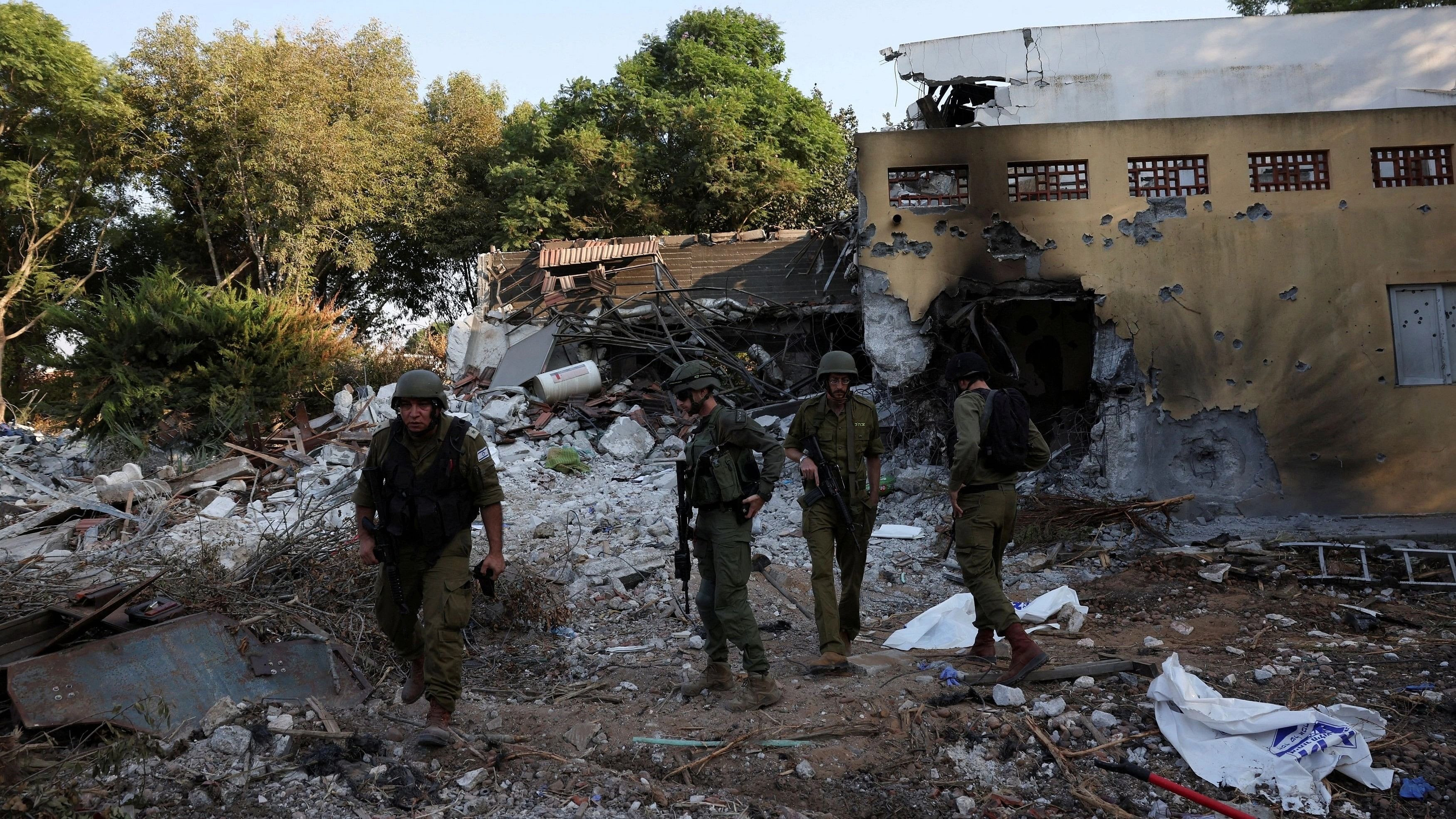 <div class="paragraphs"><p>Israeli soldiers walk, in the aftermath of a mass infiltration by Hamas gunmen from the Gaza Strip, in Kibbutz Beeri in southern Israel.</p></div>