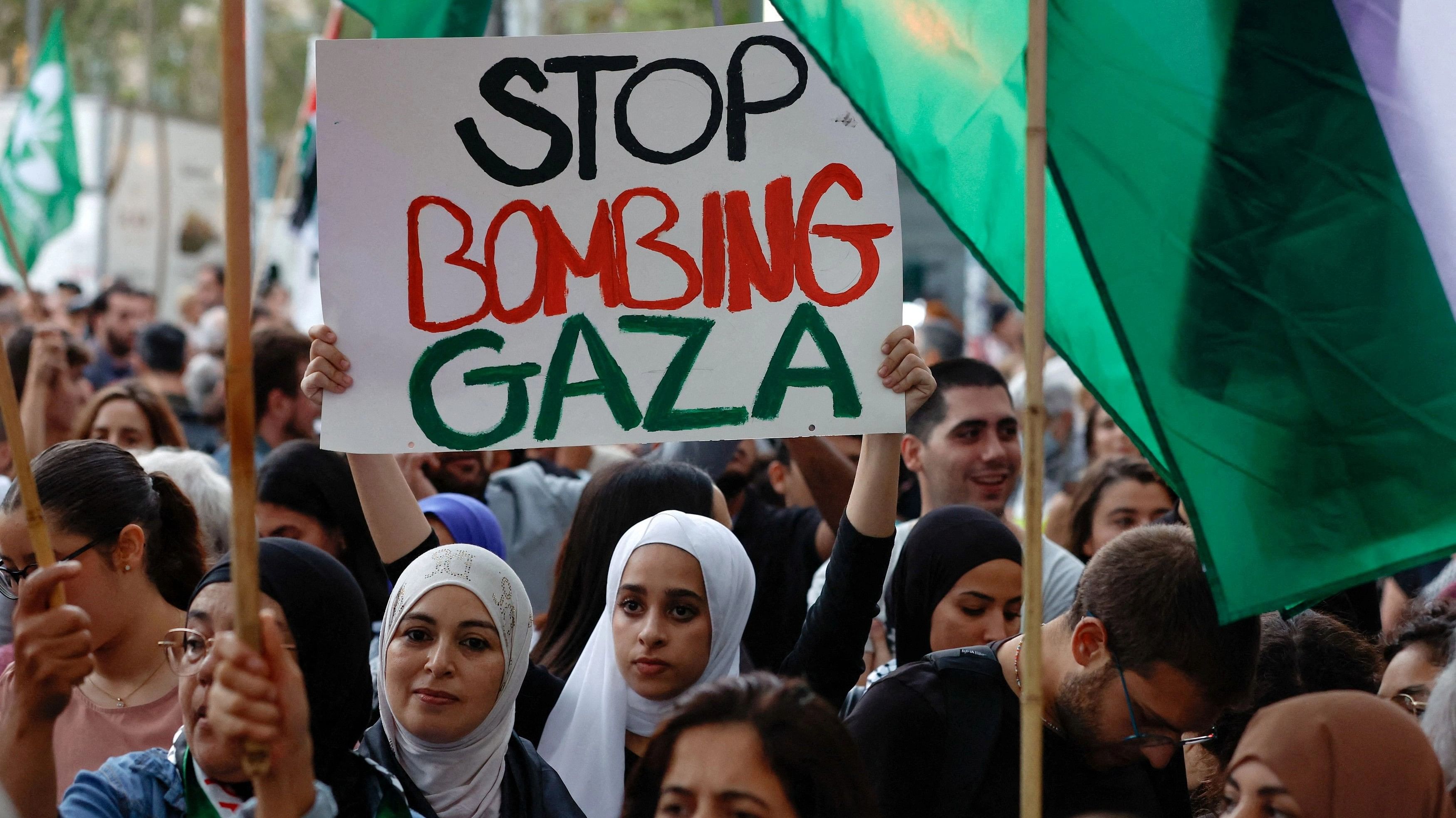 <div class="paragraphs"><p>Supporters hold signs during a pro-Palestinian protest amid the ongoing conflict between Israel and the Palestinian militant group Hamas, in Barcelona, Spain, October 11, 2023. </p></div>