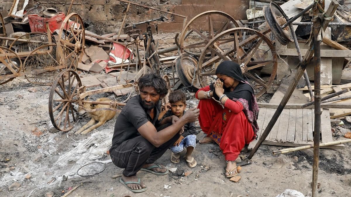 <div class="paragraphs"><p>A woman sitting with her husband and their child reacts next to damaged property after their house was burnt by a mob in a riot-affected area after clashes erupted between people demonstrating for and against a new citizenship law in New Delhi, India, February 28, 2020.</p></div>