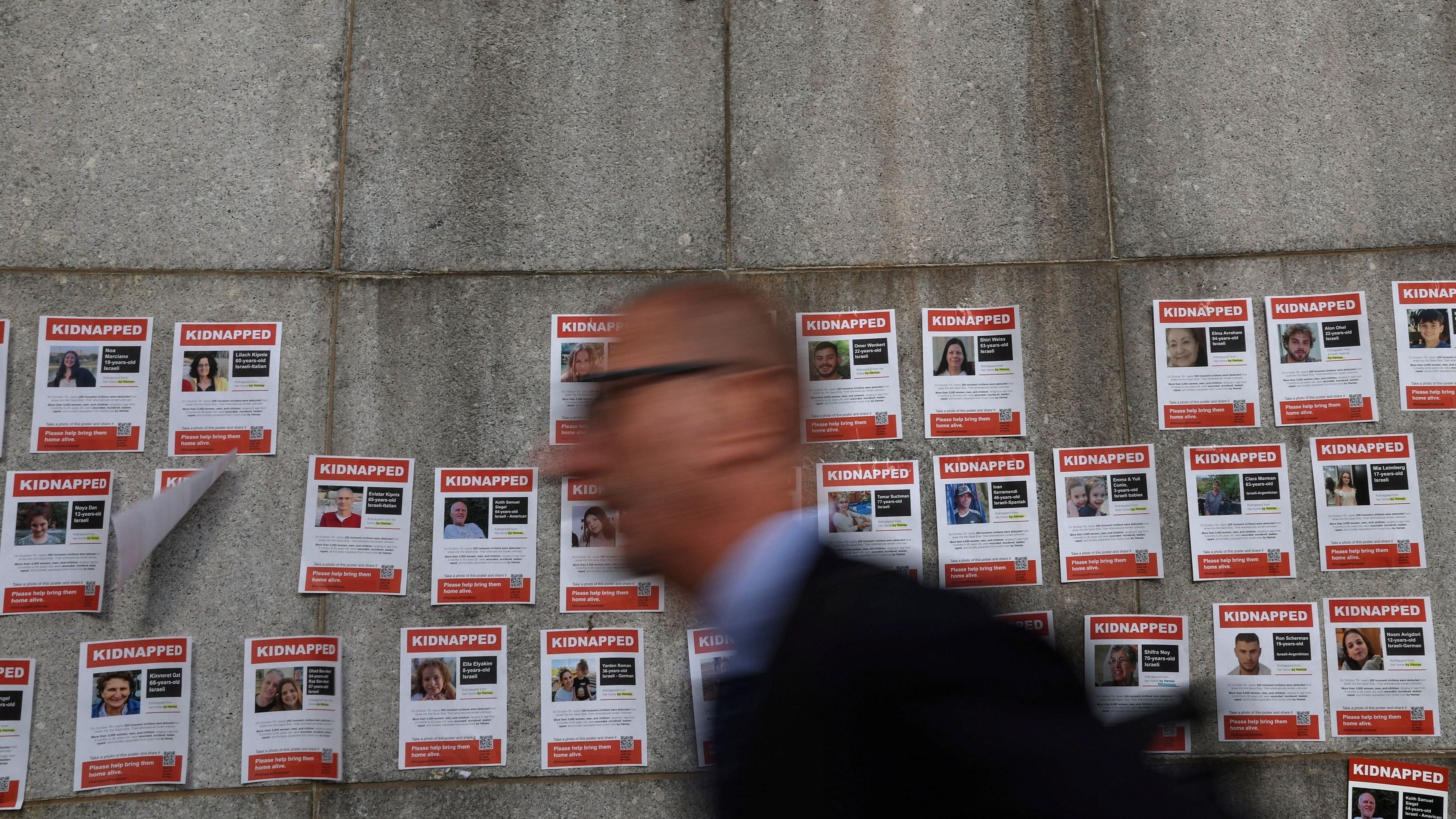 <div class="paragraphs"><p>A man walks by pictures of hostages who are being held in Gaza, amid the ongoing conflict between Israel and Hamas,  after a demonstration outside United Nations headquarters  in New York City, US, October 24, 2023. </p></div>