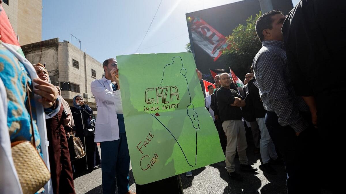 <div class="paragraphs"><p>A Palestinian holds up a sign, while taking part in a protest in support of the people of Gaza, as the conflict between Israel and Palestinian Islamist group Hamas continues, in Hebron, in the Israeli-occupied West Bank, October 25, 2023.</p></div>