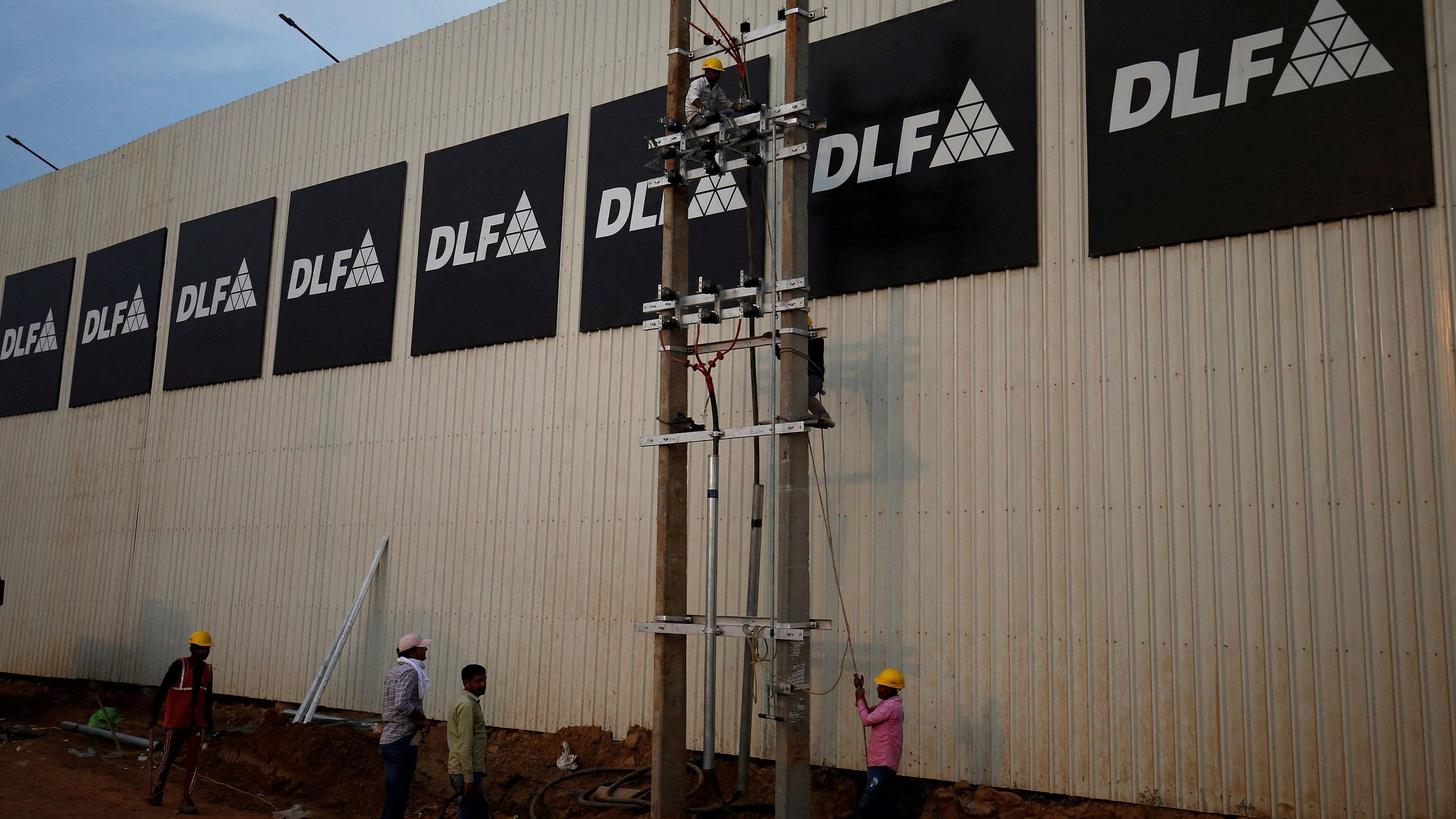 <div class="paragraphs"><p>File Photo: Workers install power lines inside a luxury residential project by property developer DLF in Gurugram, February 28, 2023. </p></div>