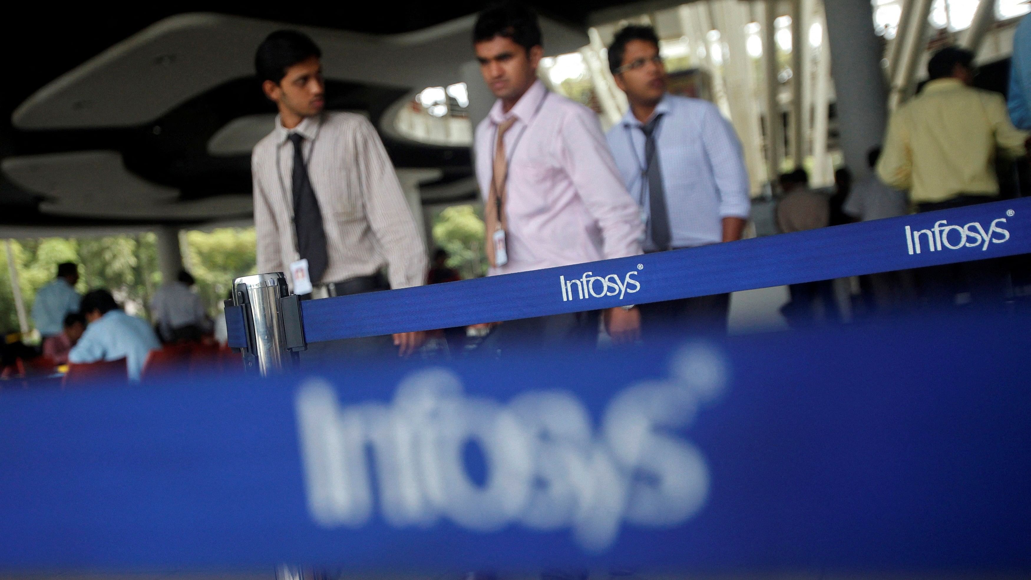 <div class="paragraphs"><p>Employees of Indian software company Infosys walk past Infosys logos at their campus in the Electronic City area in Bangalore.&nbsp;</p></div>