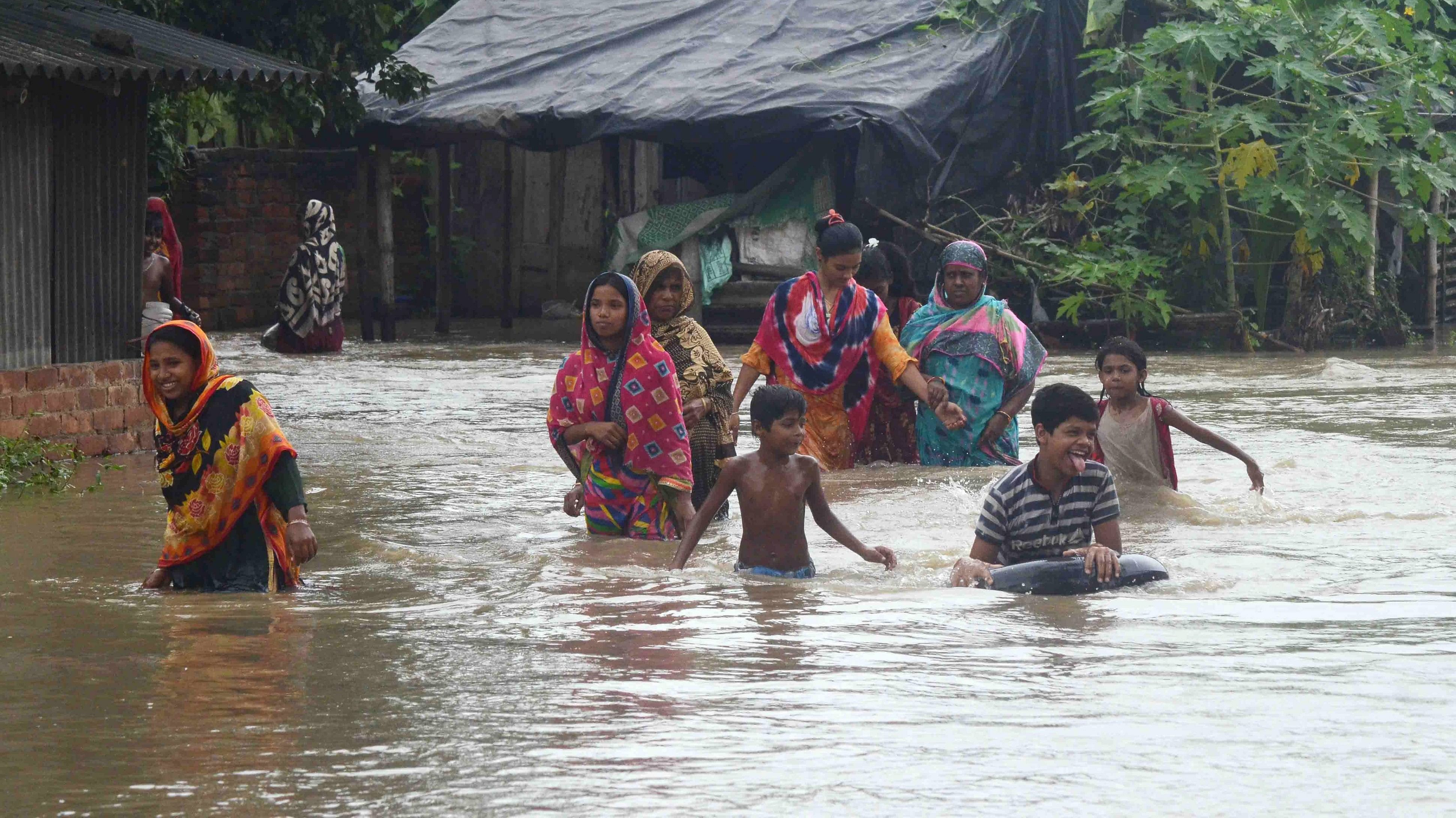<div class="paragraphs"><p>People cross a flooded area after release of water from a dam, at Udaynarayanpur in Howrah.</p></div>