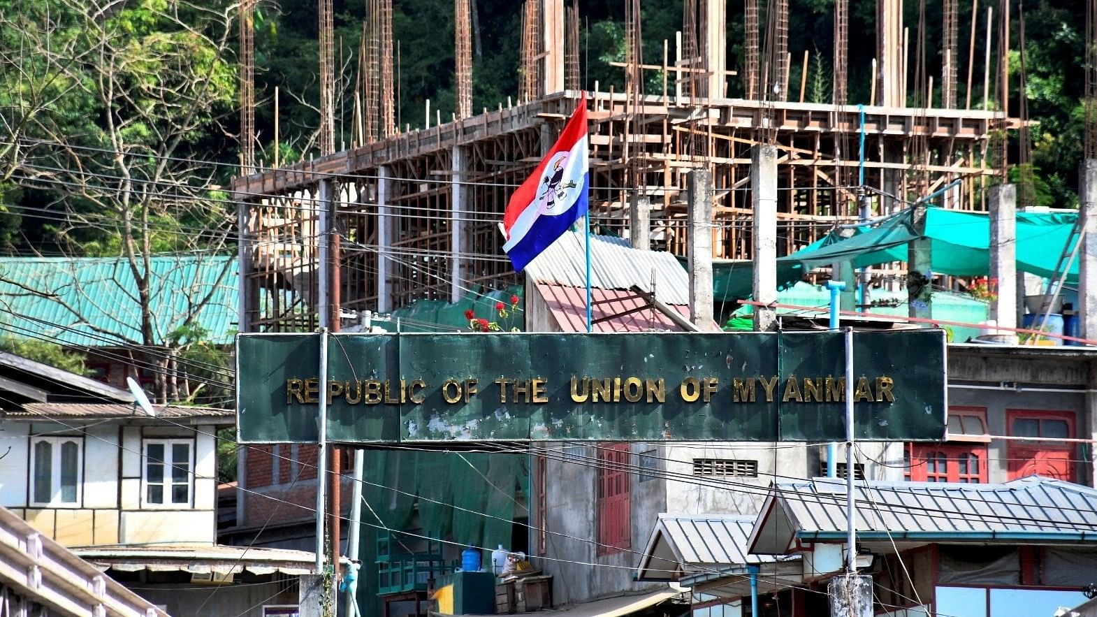 <div class="paragraphs"><p>A flag of one of the Myanmar rebel forces is installed next to an under-construction structure in Myanmar's Khawmawi village on the India-Myanmar border as seen from Zokhawthar village in Champhai district of India's northeastern state of Mizoram.</p></div>