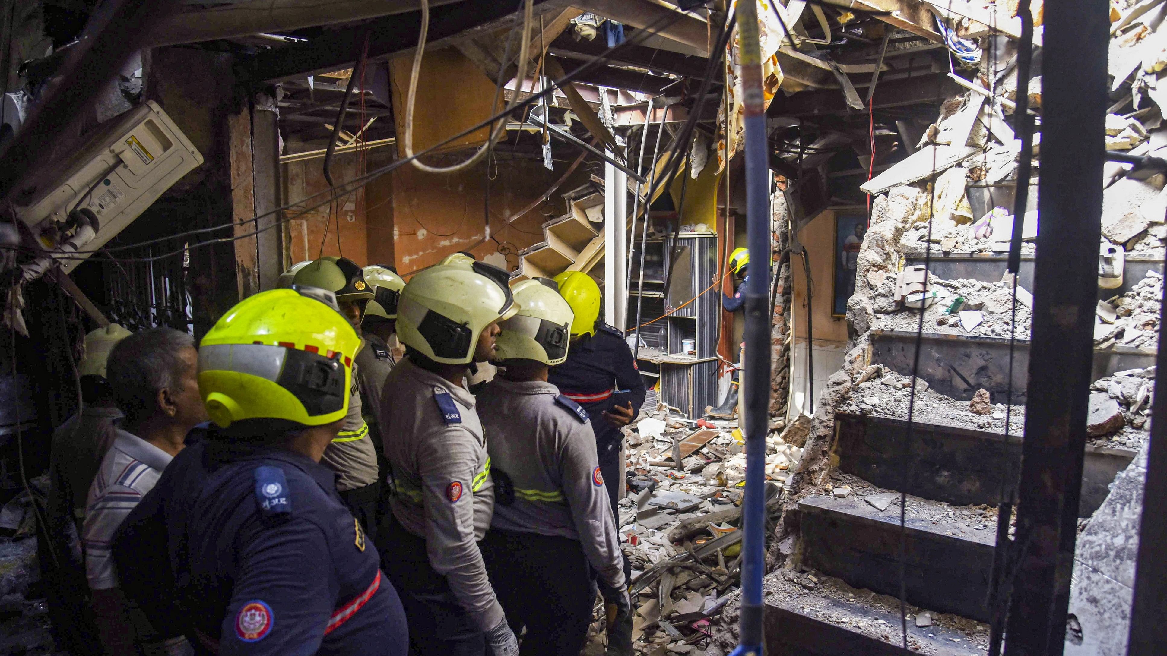 <div class="paragraphs"><p>Mumbai: Firemen and others clean the debris after a gas cylinder exploded in a house at Chembur, in Mumbai, Wednesday, Nov. 29, 2023. </p></div>