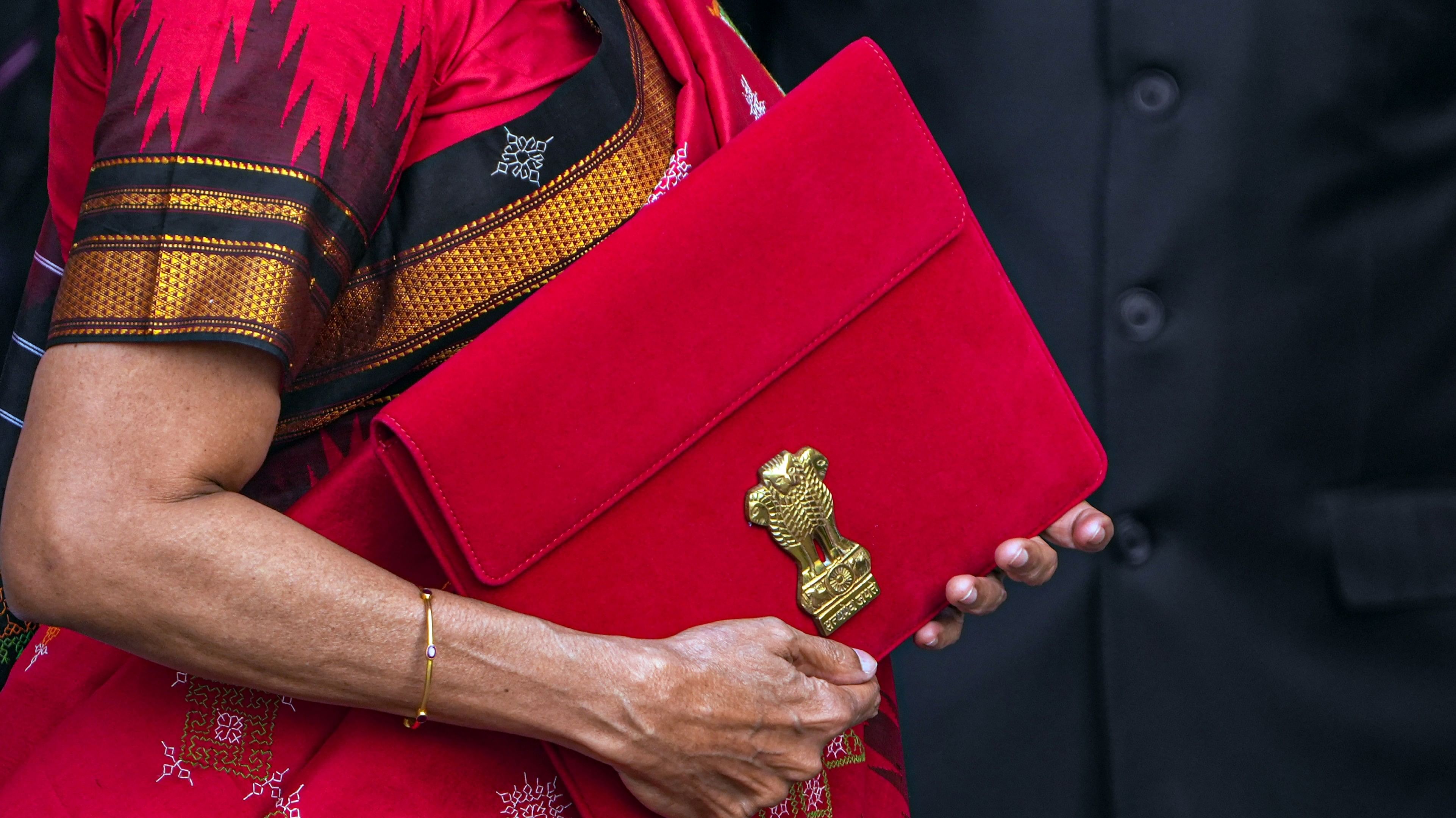 <div class="paragraphs"><p>Union Finance Minister Nirmala Sitharaman carrying a folder-case poses for photographs outside the Finance Ministry</p></div>