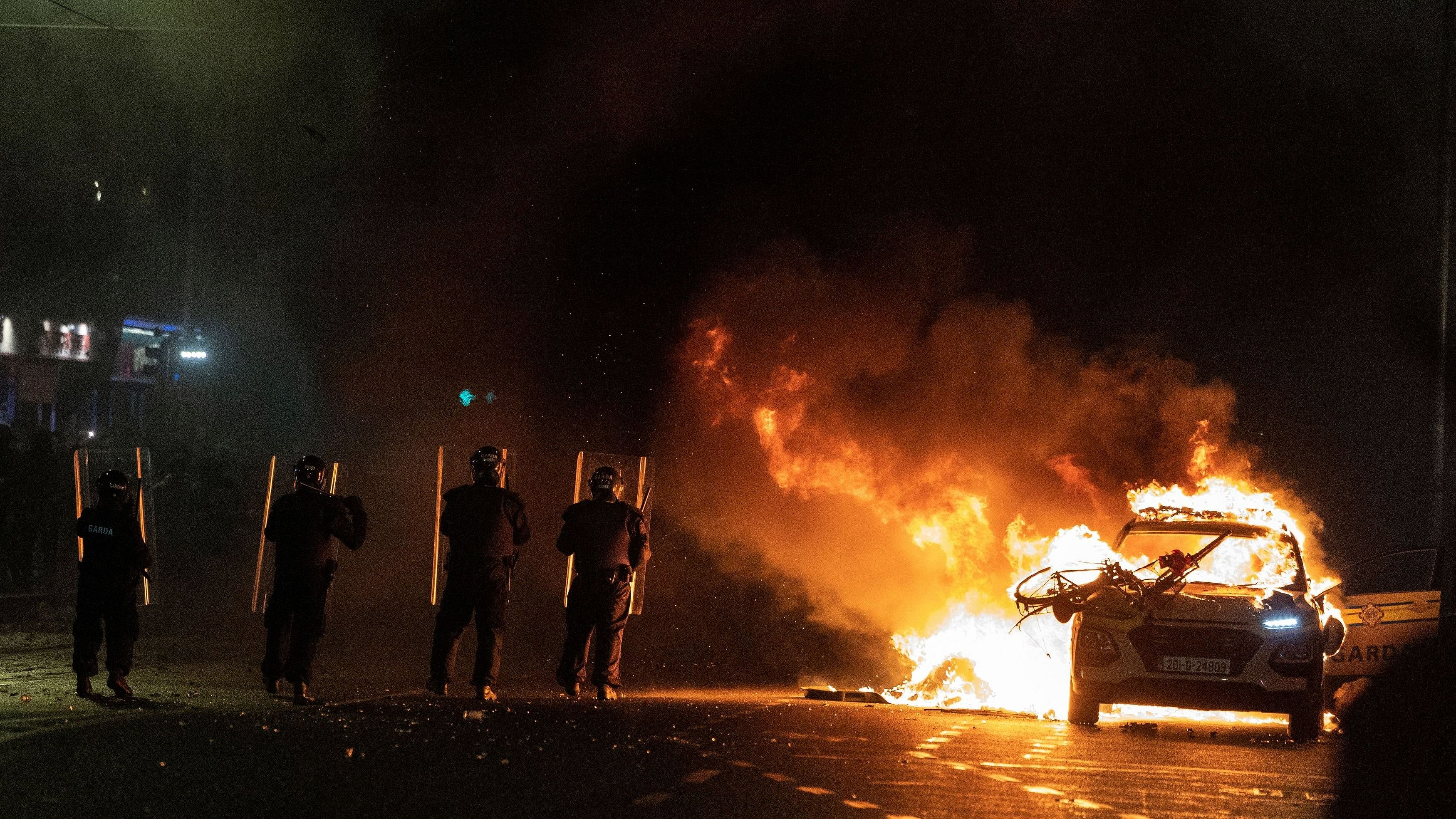 <div class="paragraphs"><p>Riot police officers face down demonstrators next to a burning police car near a crime scene of a school stabbing that left several children and adults injured, in Dublin, Ireland, November 23, 2023. </p></div>