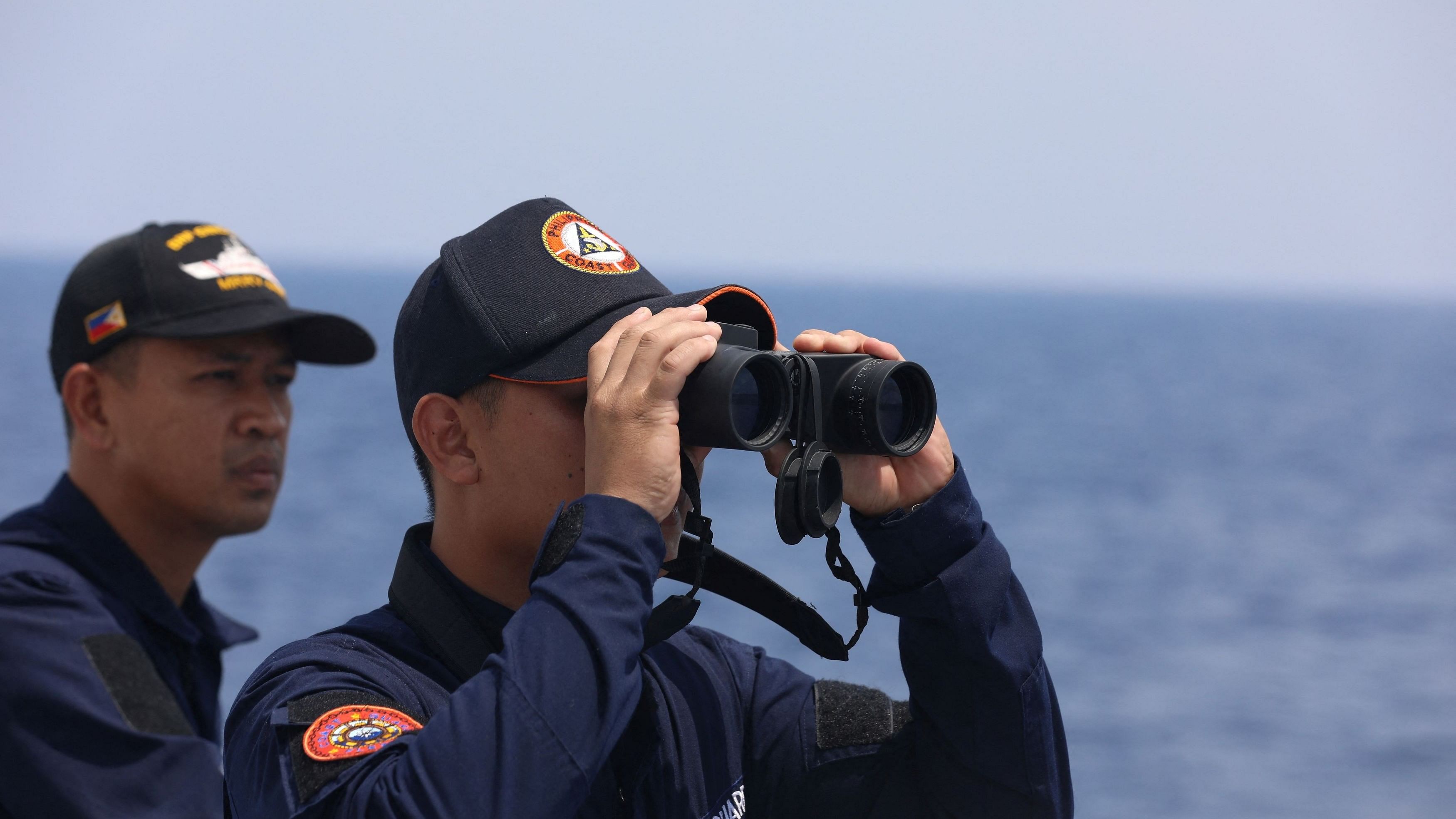 <div class="paragraphs"><p>A Philippine Coast Guard personnel looks through a binocular while conducting a resupply mission for Filipino troops stationed at a grounded warship in the South China Sea.</p></div>