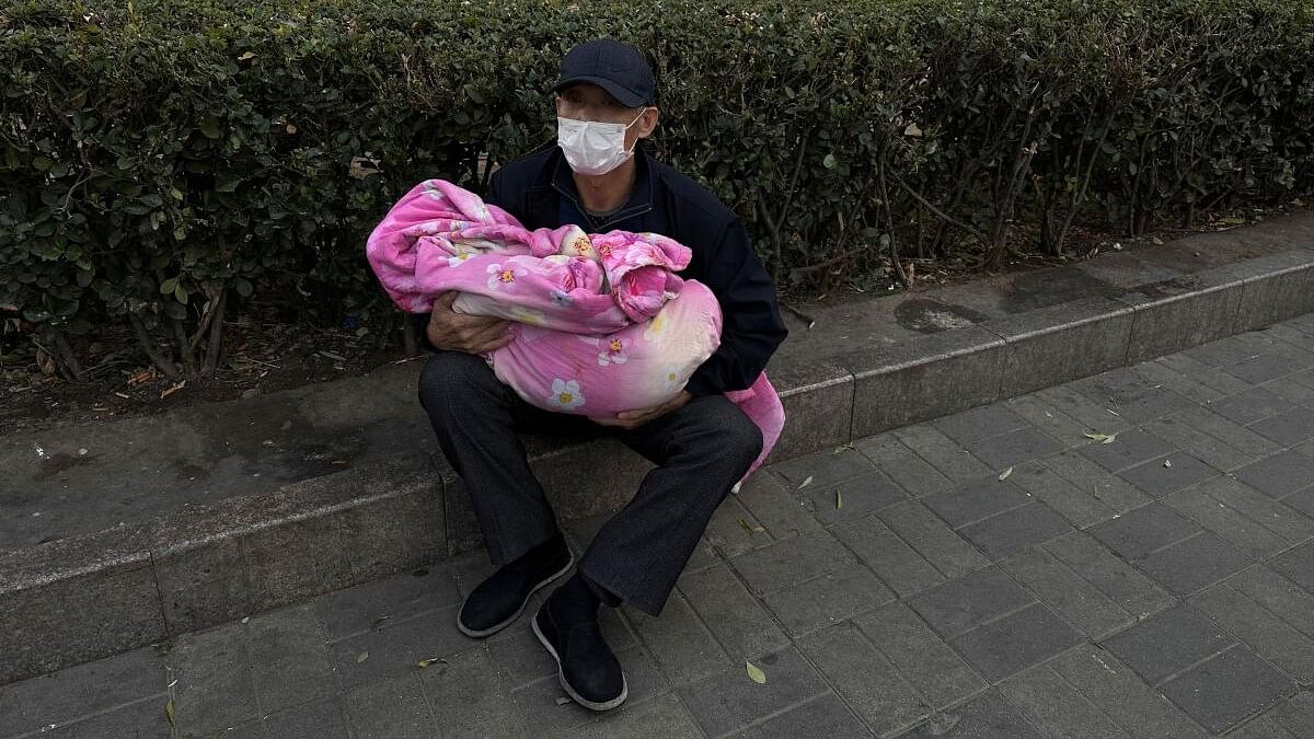 <div class="paragraphs"><p>A man carrying a child sits outside a children's hospital in Beijing, China November 27, 2023.</p></div>