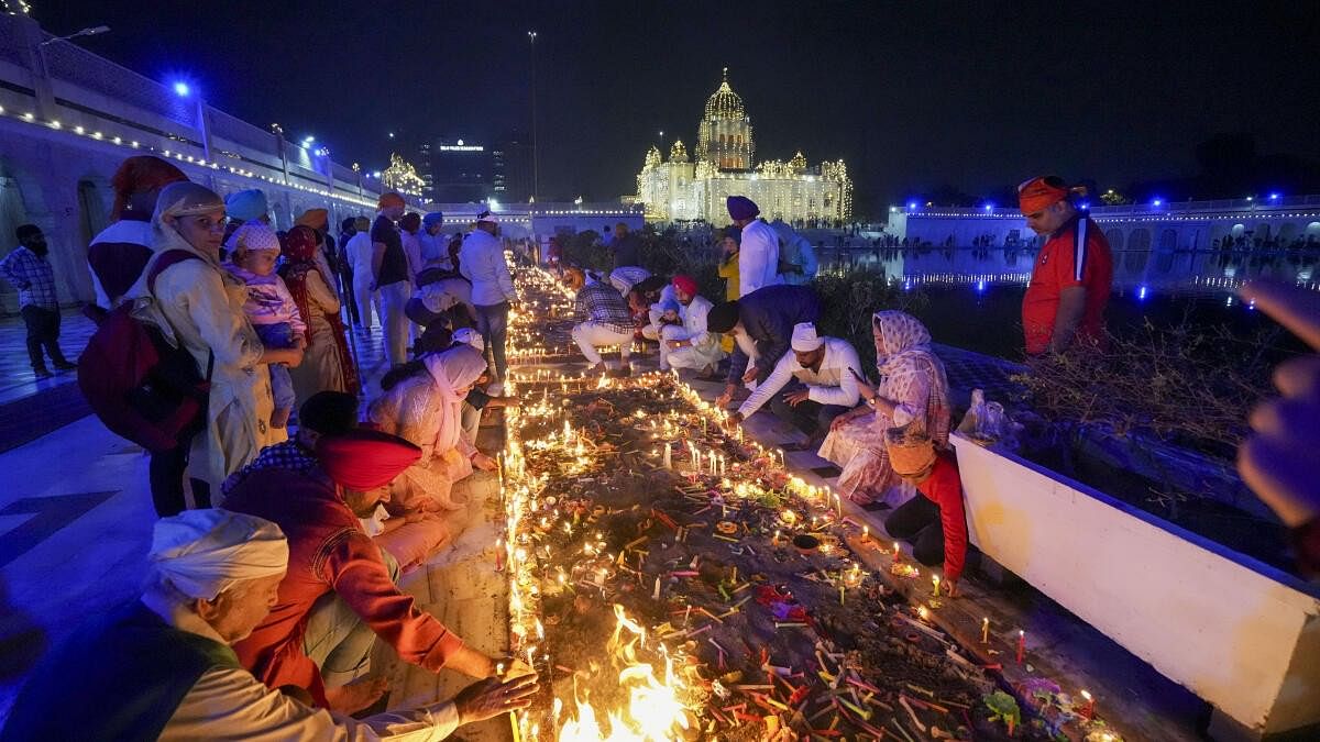 <div class="paragraphs"><p>People light candles at the illuminated Gurdwara Bangla Sahib during the Diwali celebration, in New Delhi, Sunday, Nov. 12, 2023.</p></div>