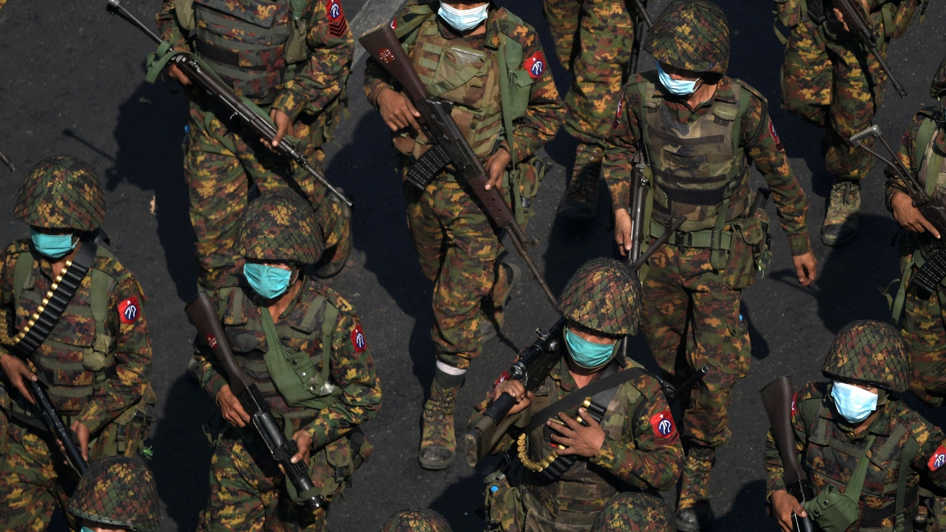 <div class="paragraphs"><p>Myanmar soldiers walk along a street during a protest.&nbsp;</p></div>