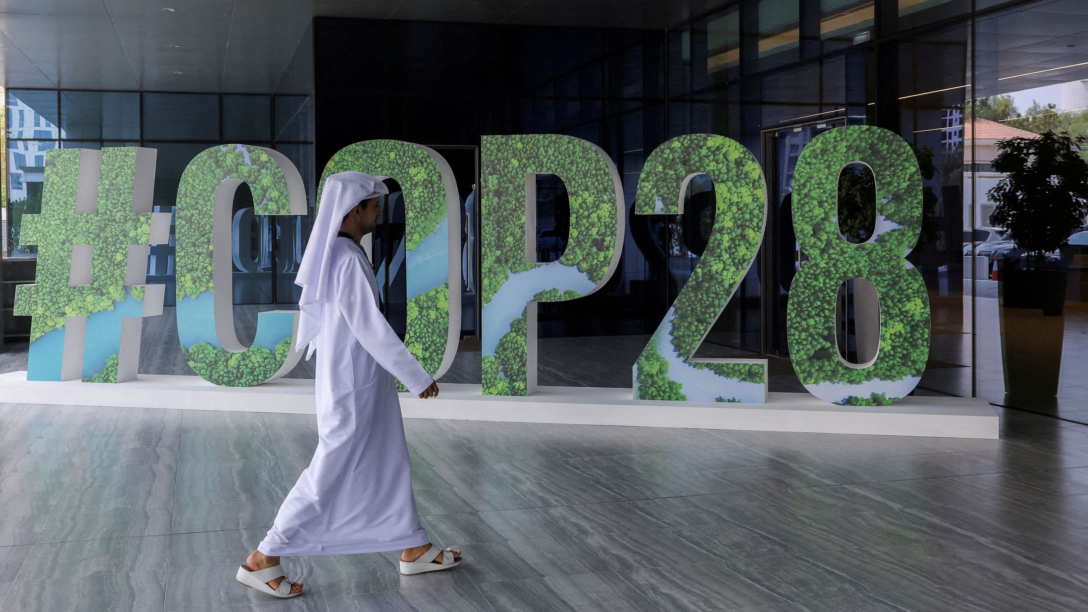 <div class="paragraphs"><p> A person walks past a '#COP28' sign in Abu Dhabi, United Arab Emirates.</p></div>