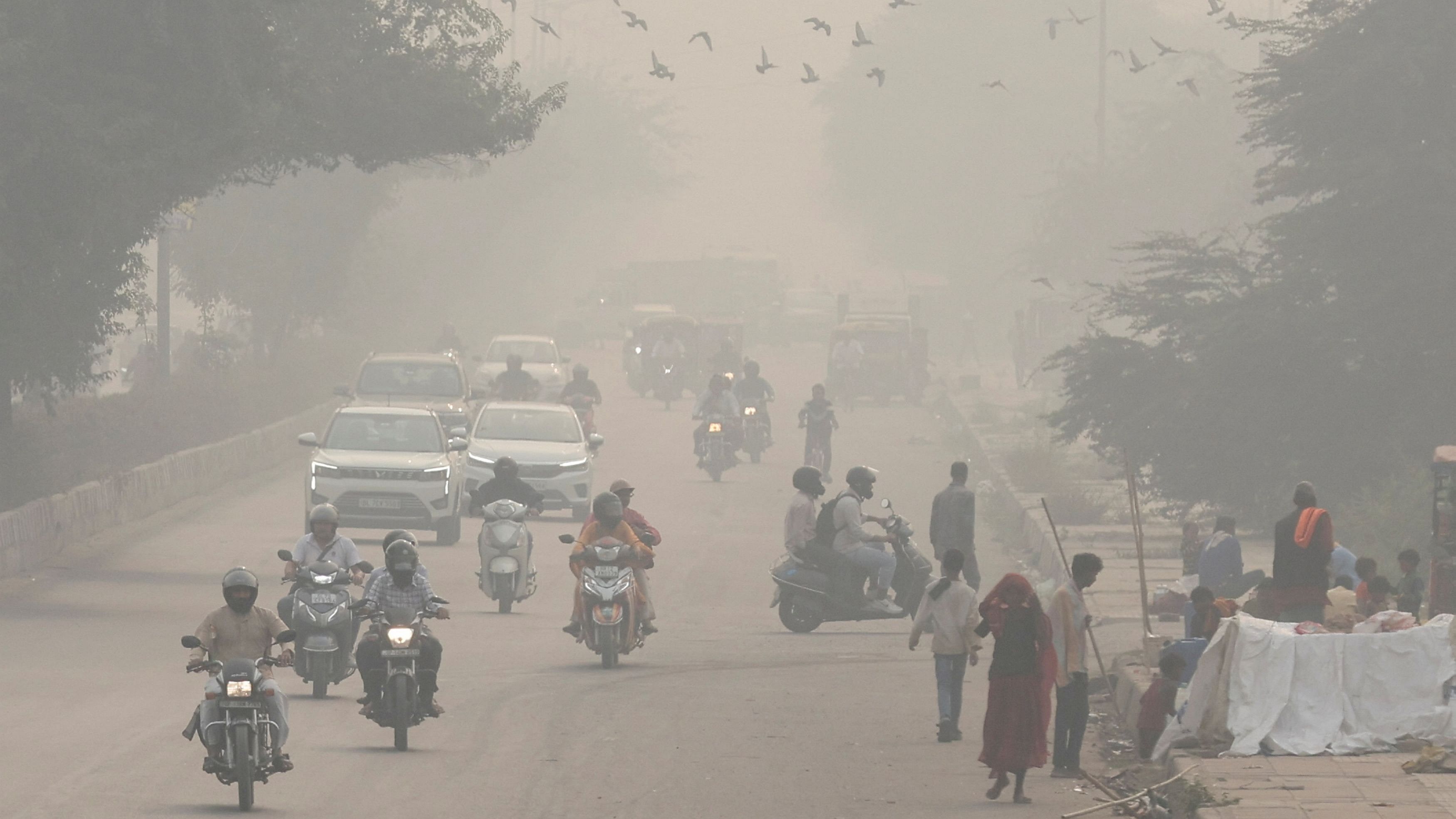 <div class="paragraphs"><p>People and vehicles are seen on a road amidst the morning smog in New Delhi, India, November 8, 2023.</p></div>