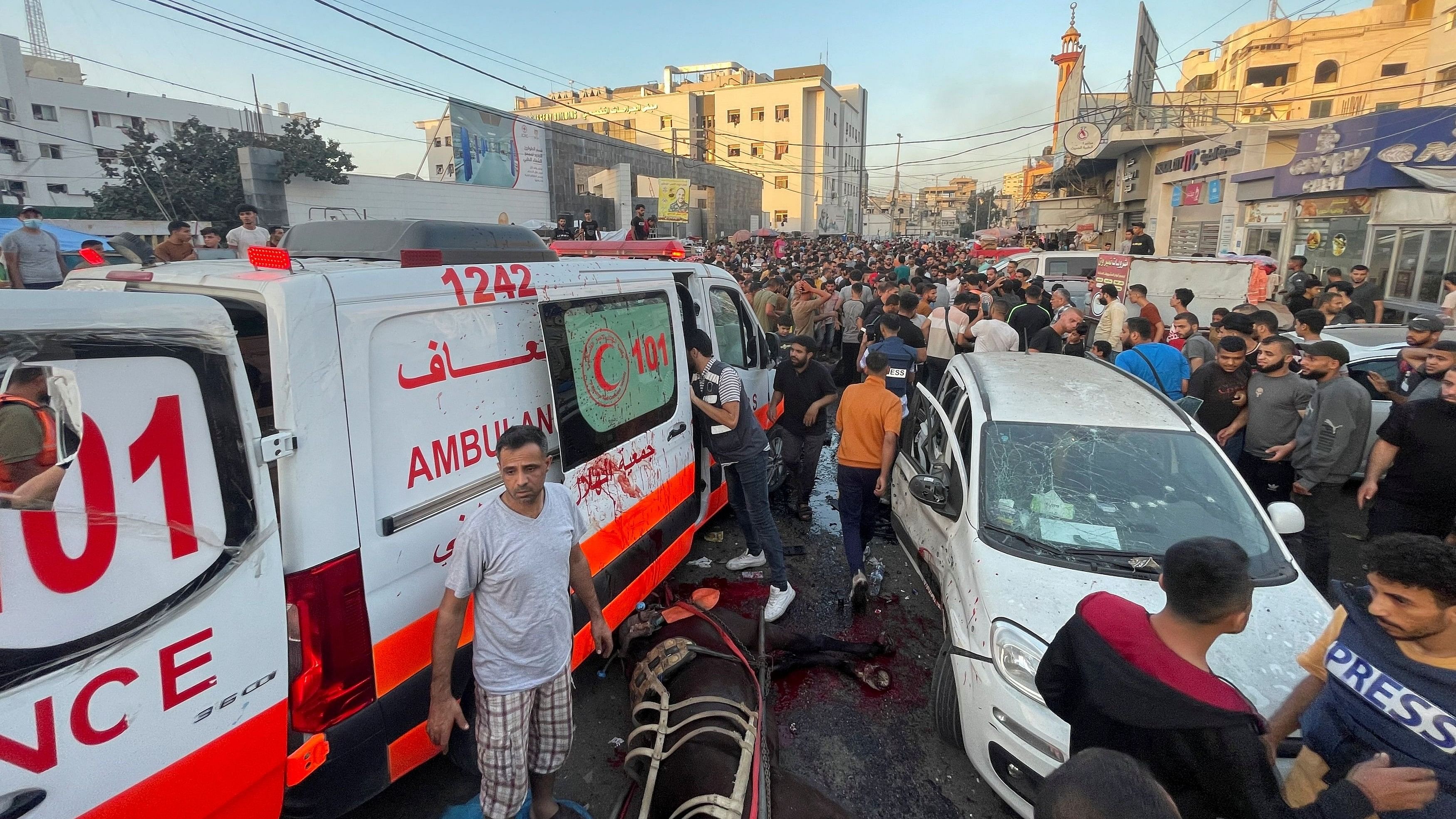 <div class="paragraphs"><p>Palestinians check the damages after a convoy of ambulances was hit, at the entrance of Shifa hospital in Gaza City.</p></div>