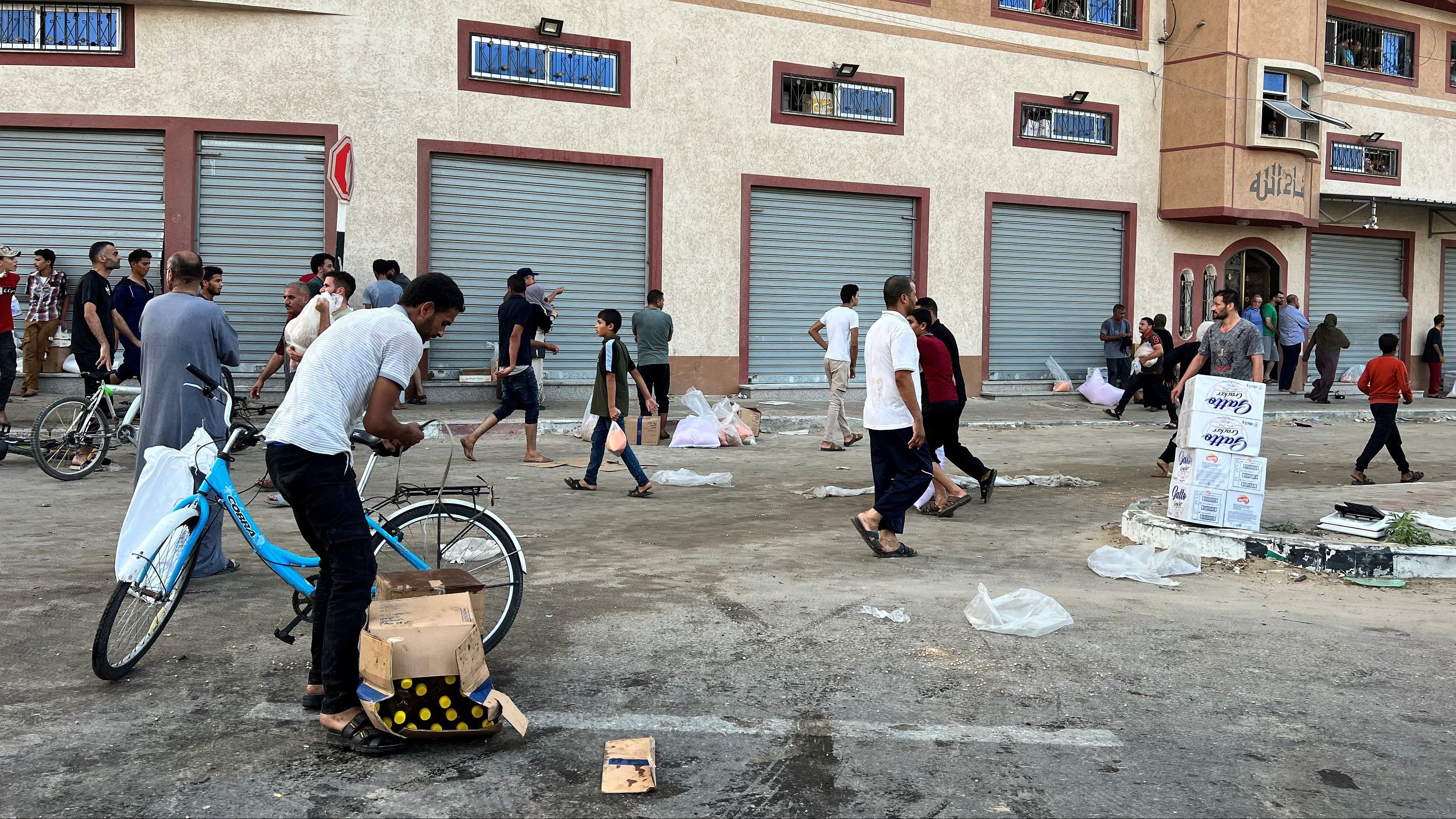 <div class="paragraphs"><p>Palestinians carry food supplies near a United Nations Palestinian refugee agency (UNRWA) run warehouse in Khan Younis.&nbsp;</p></div>