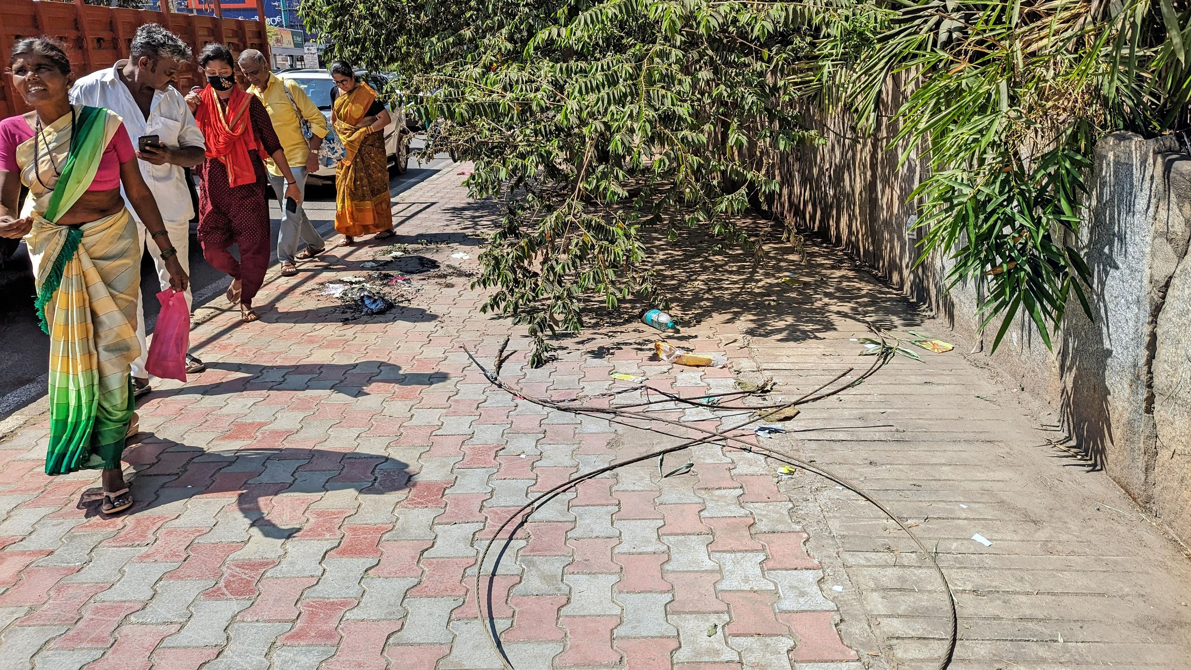 <div class="paragraphs"><p>Pedestrians walk past the spot of the accident, where a woman and her nine-month-old baby were electrocuted.&nbsp;</p></div>