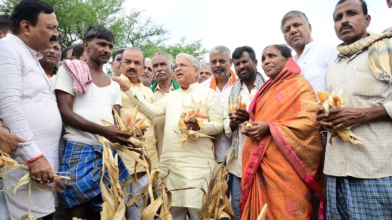 <div class="paragraphs"><p>Former DCM Govind Karjol interacts with a farmer in drought-hit maize fields near Chabbi village in Hubballi Rural taluk on Sunday. </p></div>