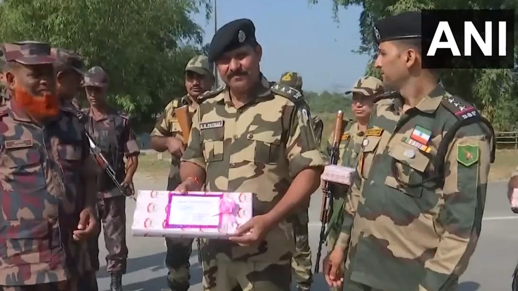 <div class="paragraphs"><p>Screengrab of video showing BSF and BGB personnel exchanging sweets.</p></div>