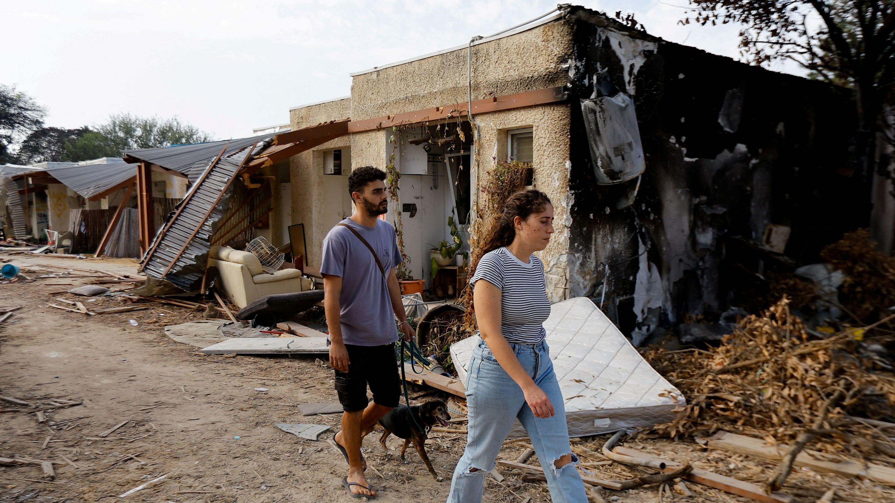 <div class="paragraphs"><p>People walk past a destroyed house following the deadly October 7 attack by Hamas gunmen from the Gaza Strip.</p></div>