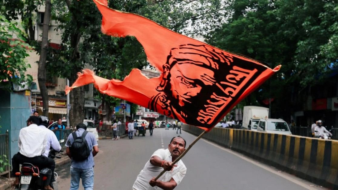 <div class="paragraphs"><p>A man waves a flag as he blocks a road during a protest, organised by Maharashtra state's Maratha community, to press their demands for reserved quotas in government jobs and college places for students in Mumbai, India July 25, 2018. </p></div>