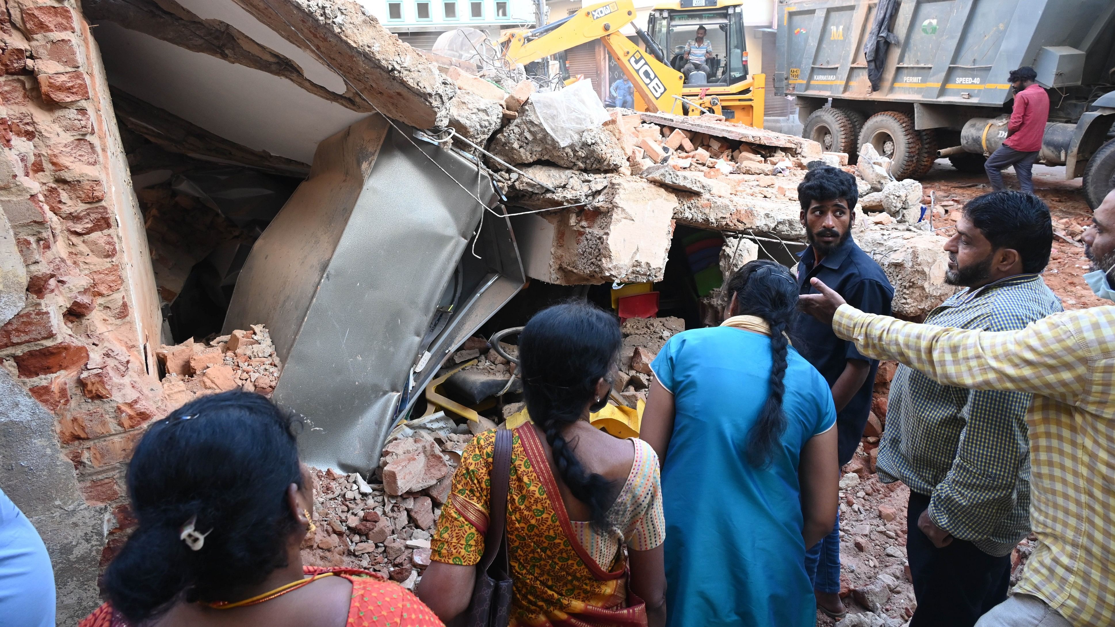 <div class="paragraphs"><p>Officials inspect the collapsed building in Shivajinagar. It collapsed in the earlt hours on Monday. </p></div>