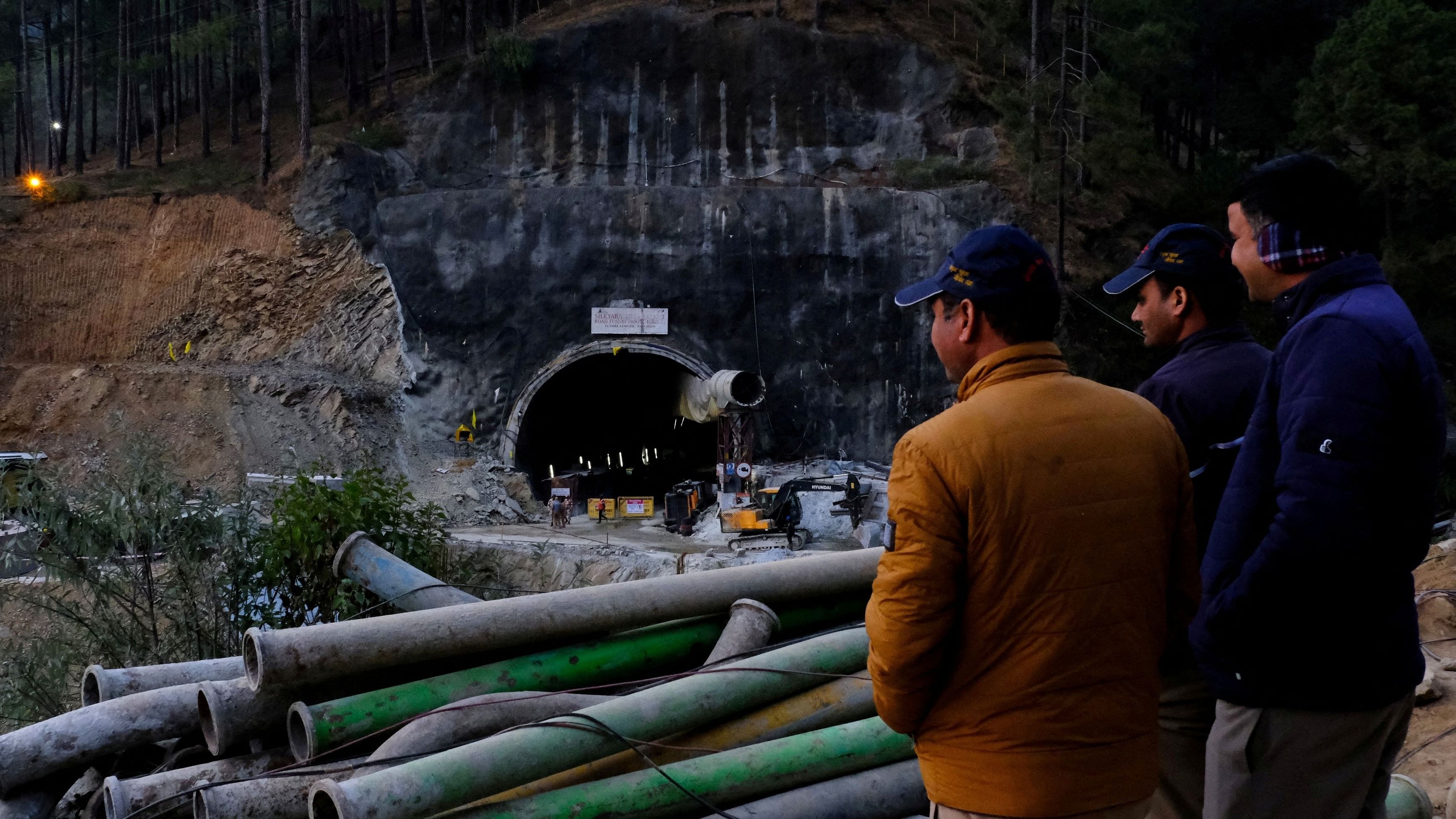 <div class="paragraphs"><p>Men overlook the entrance of a tunnel where workers have been trapped in Uttarkashi.</p></div>