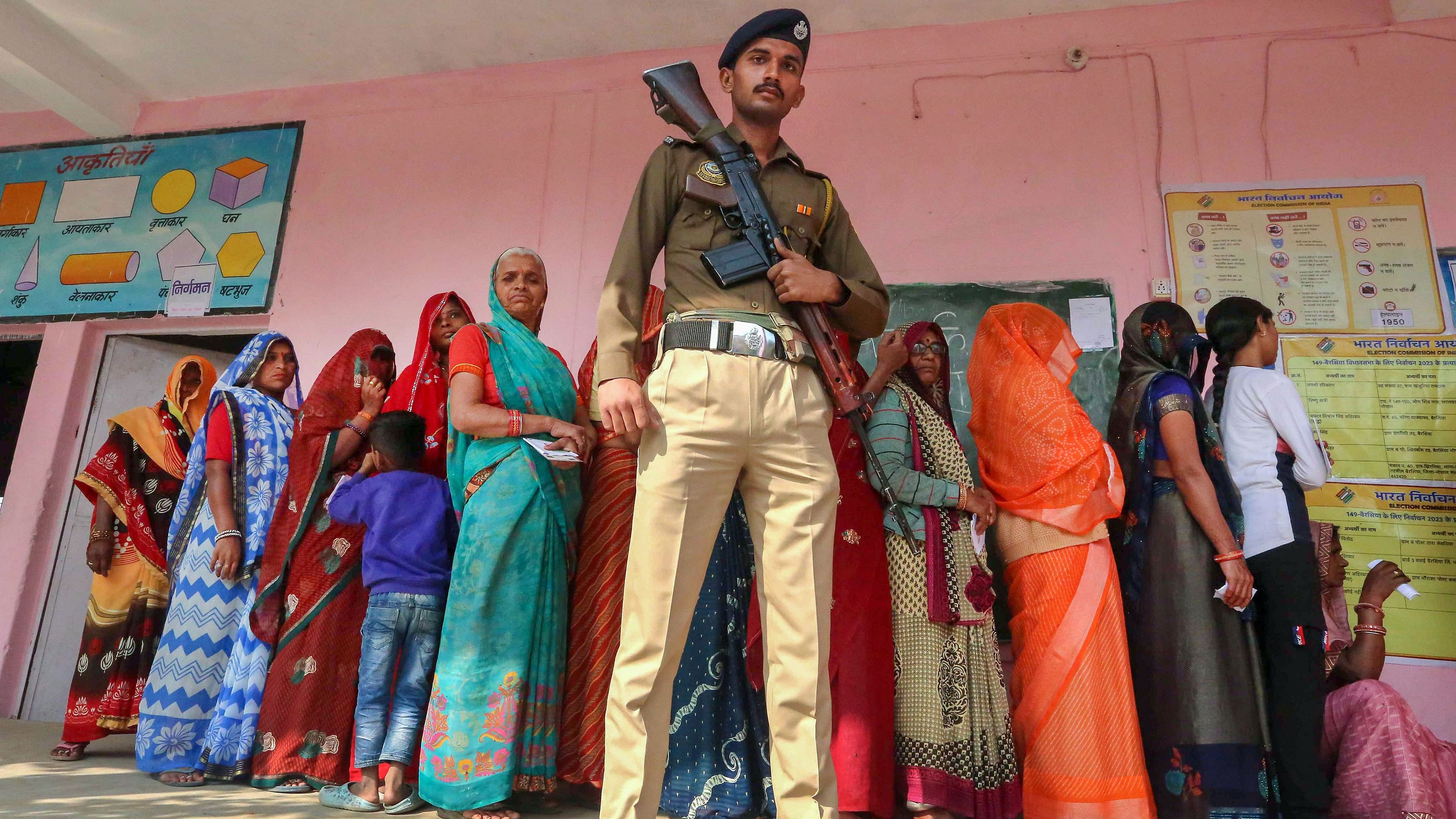 <div class="paragraphs"><p>A police officer stands guard as women voters wait in queue to cast their votes at a polling booth during Madhya Pradesh Assembly elections, in the outskirts of Bhopal.&nbsp;</p></div>