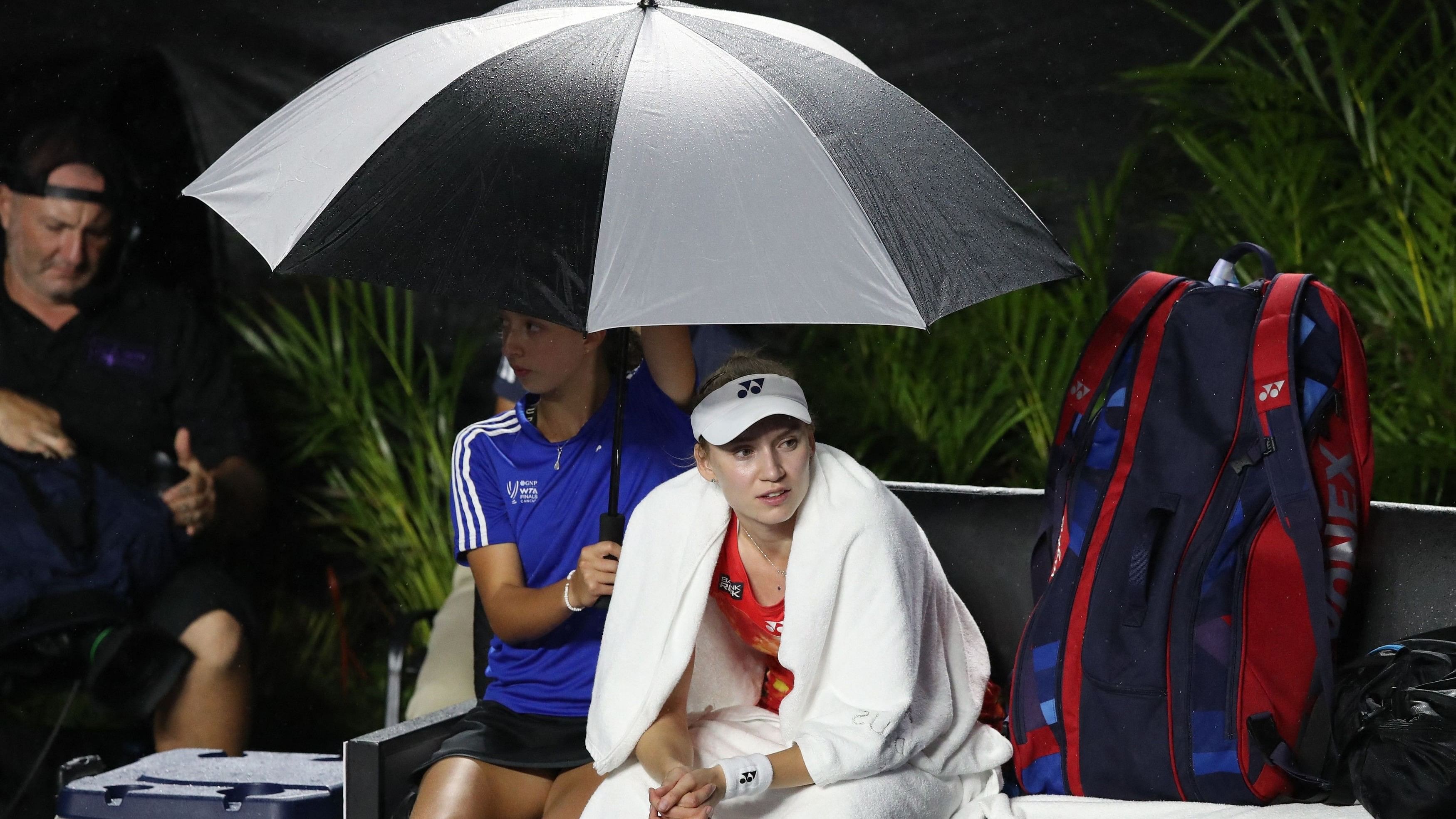 <div class="paragraphs"><p>  Kazakhstan's Elena Rybakina covers from the rain as the match against Belarus' Aryna Sabalenka is interrupted.</p></div>