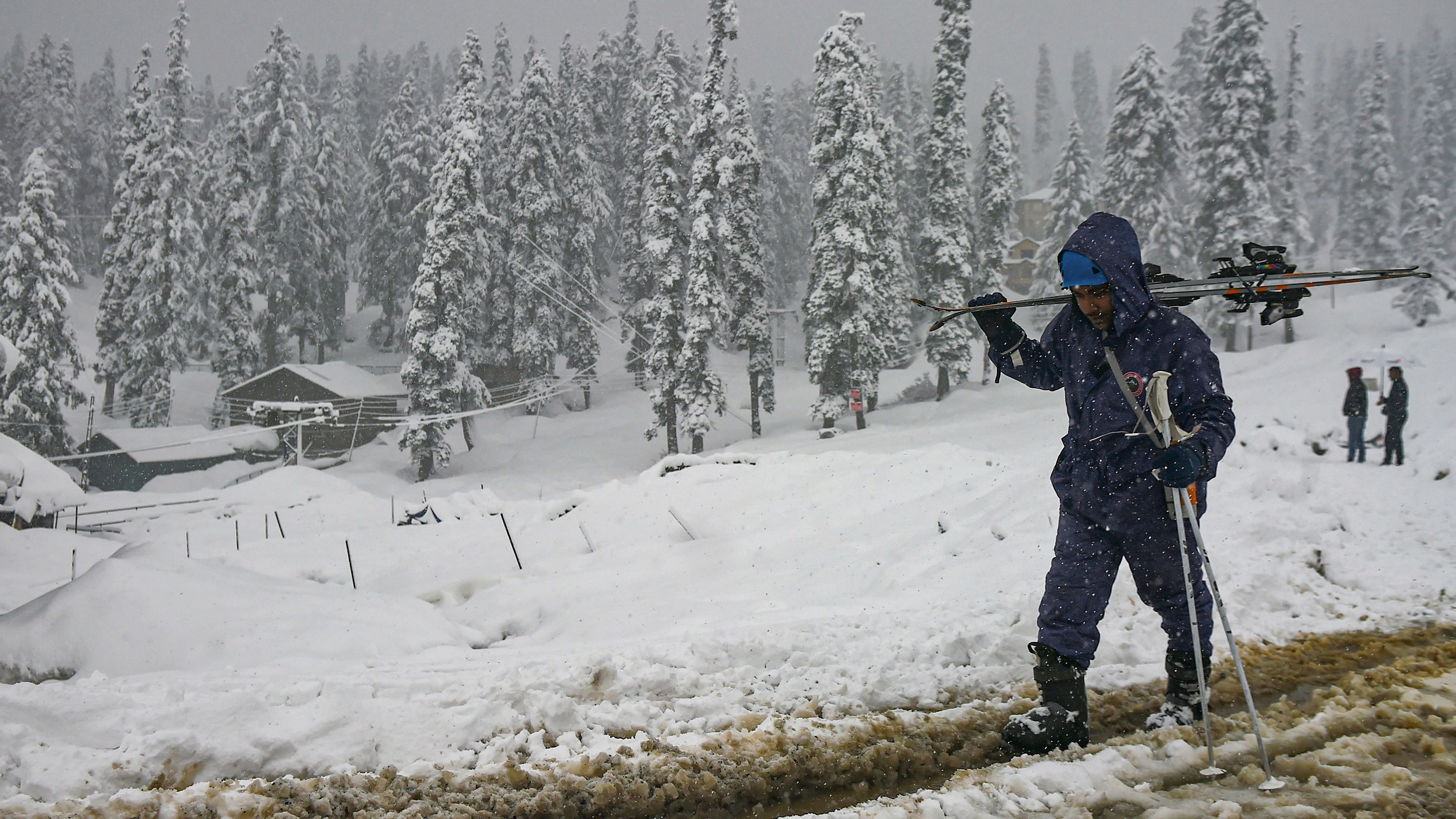 <div class="paragraphs"><p>A skier walks on a snow-covered road during heavy snowfall at the ski resort of Gulmarg. </p></div>