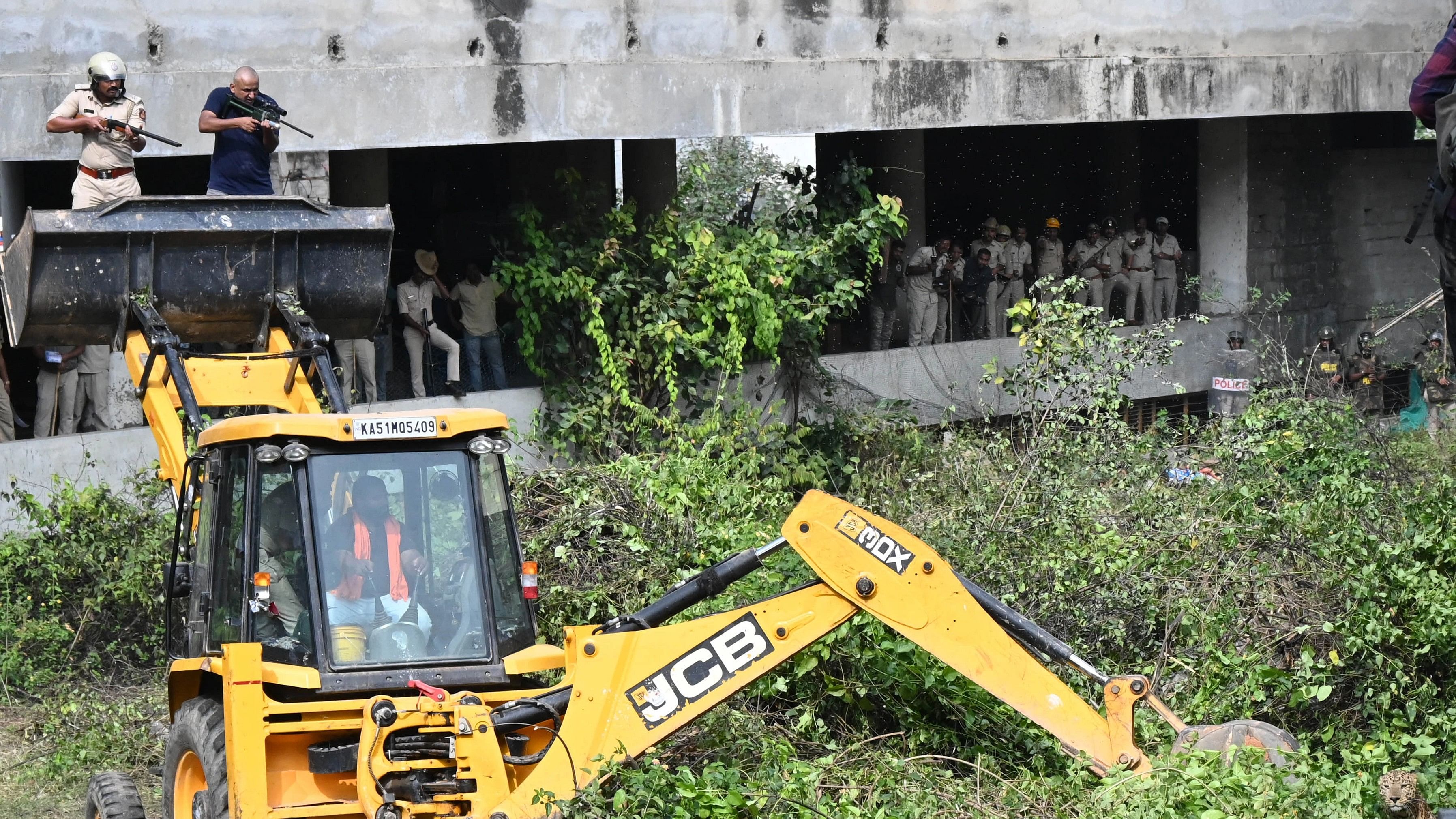 <div class="paragraphs"><p>Forest department officials zero in on the leopard at Kudlu on Wednesday.&nbsp;</p></div>